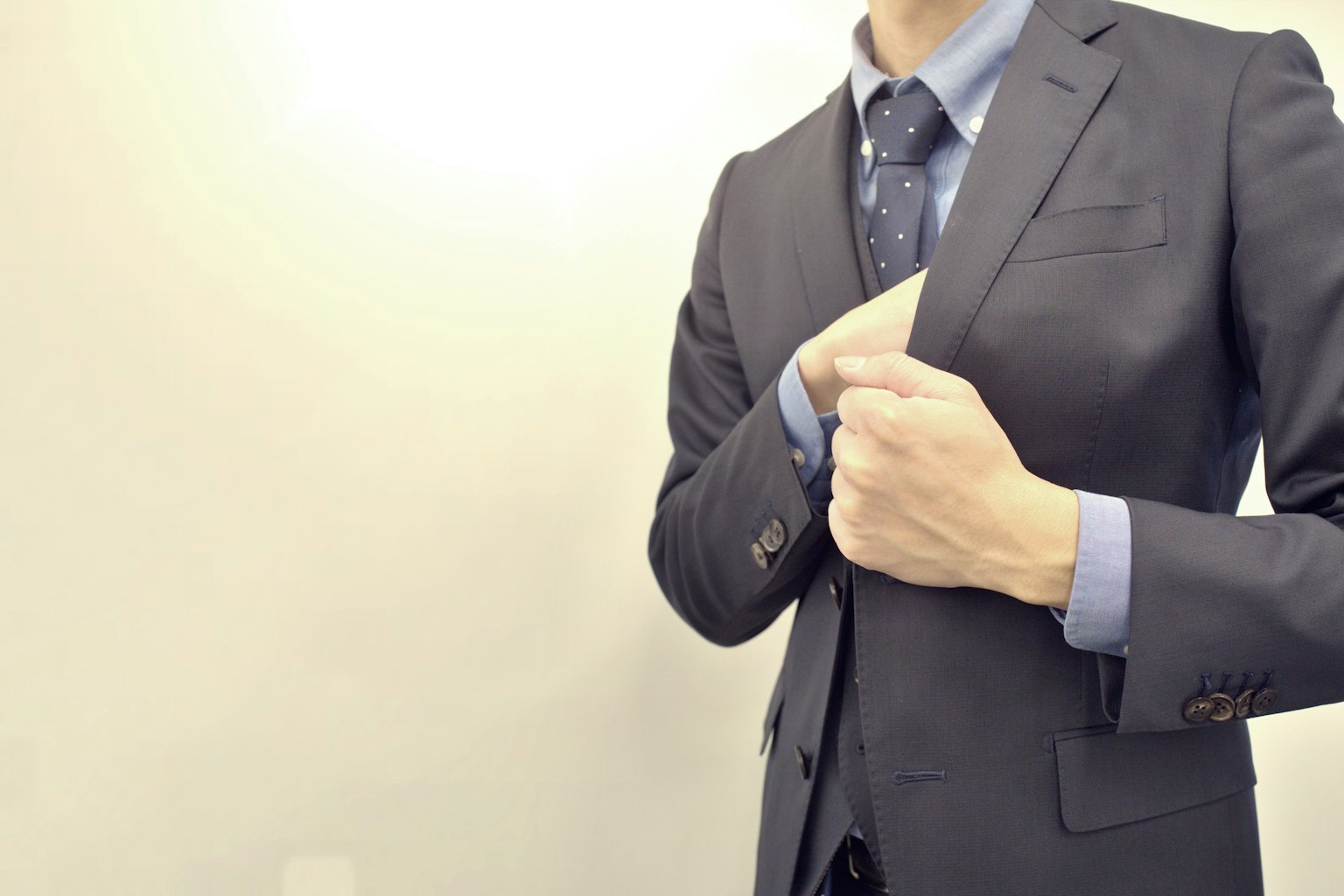 A man in a suit adjusting his jacket