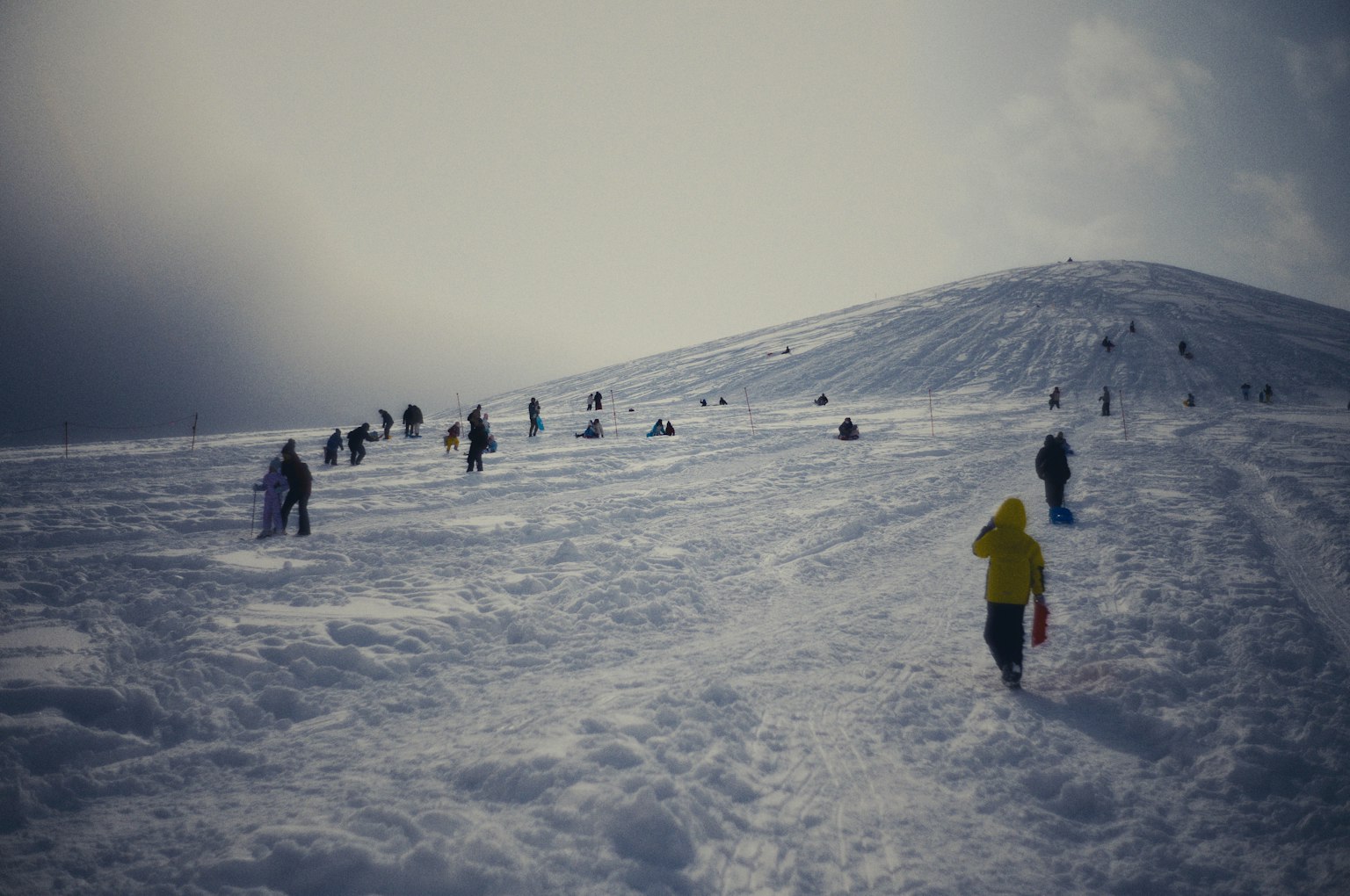 Menschen, die einen schneebedeckten Hügel im Winter erklimmen
