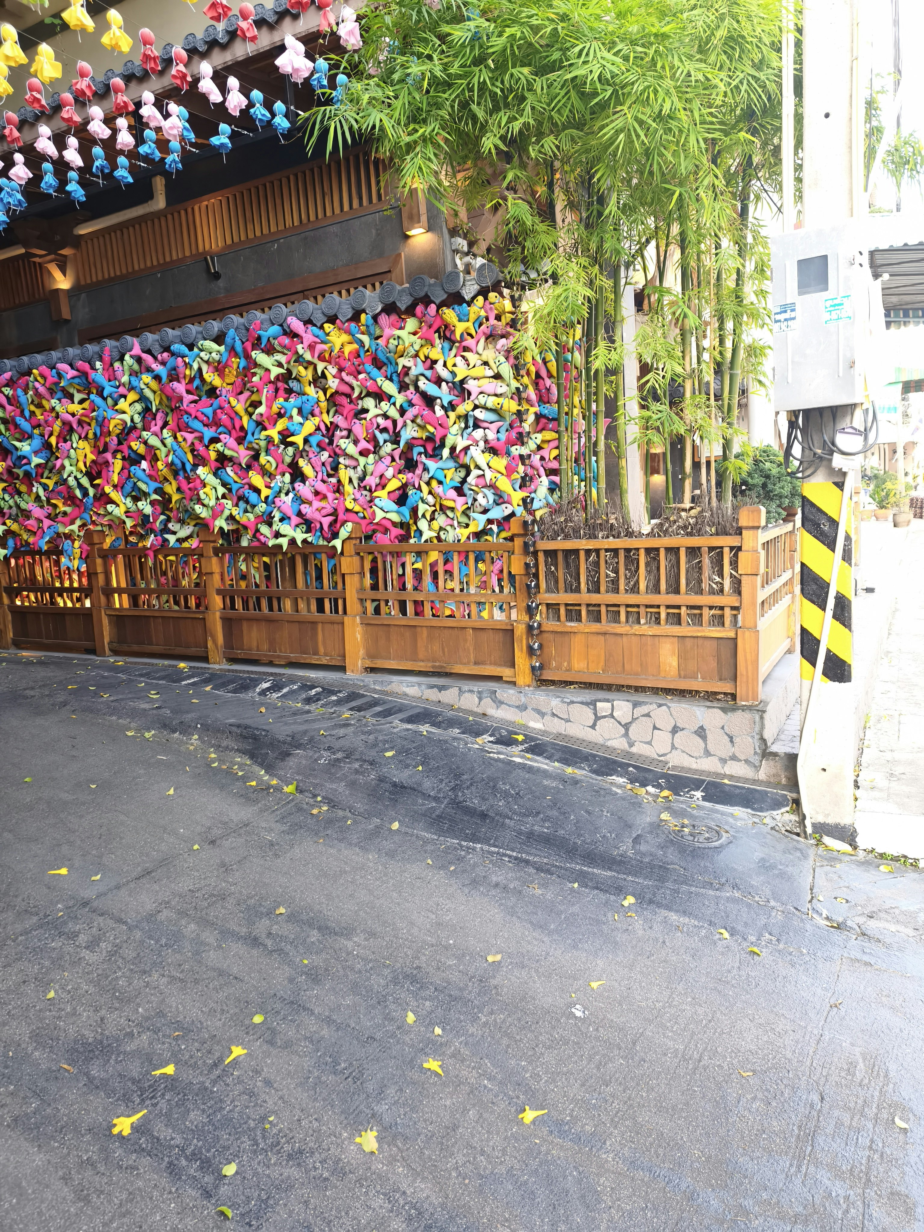 色とりどりの折り鶴が並ぶ竹垣の小道