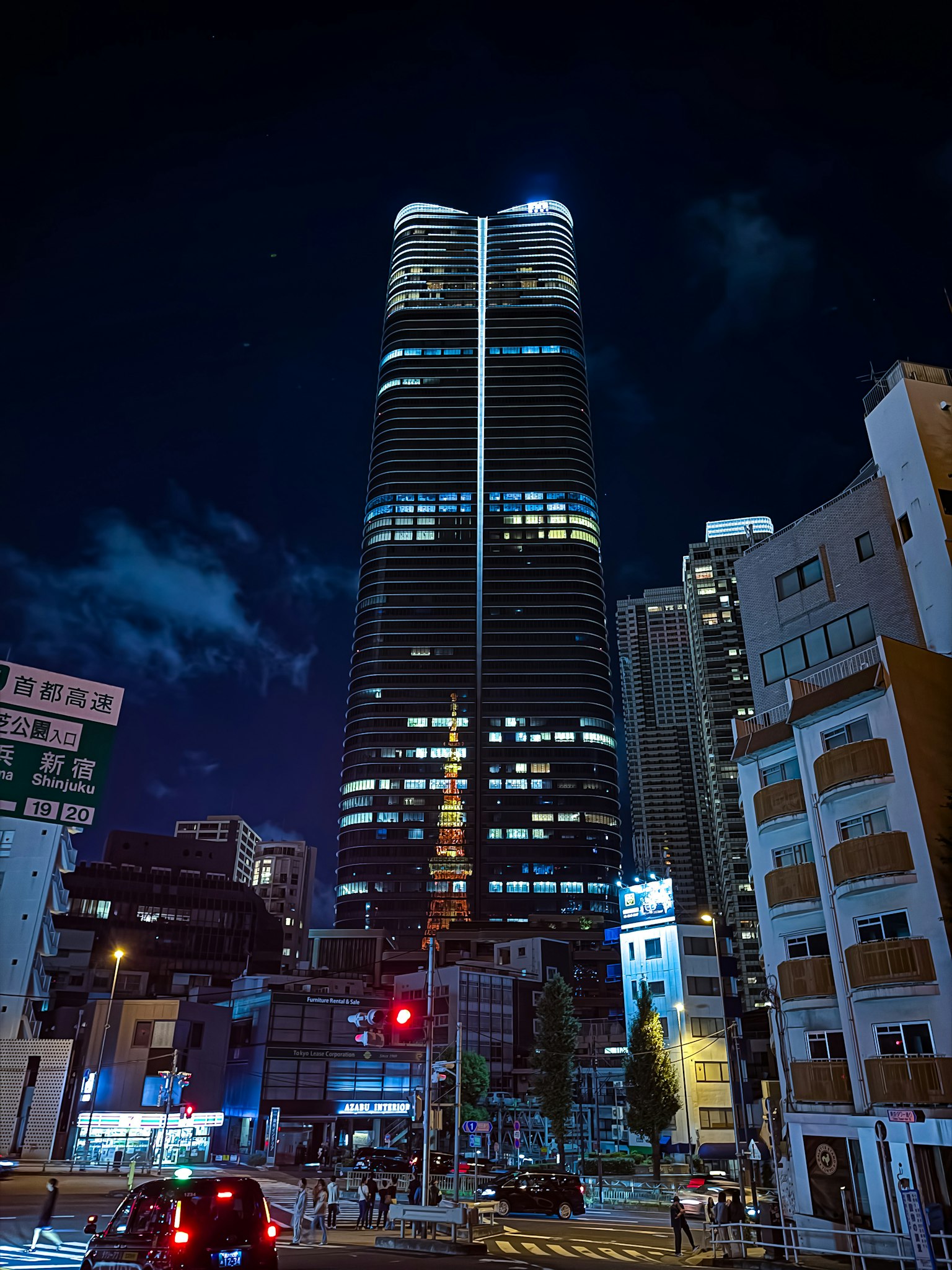 夜の東京の高層ビル群の中にそびえる東京ミッドタウンタワーの姿