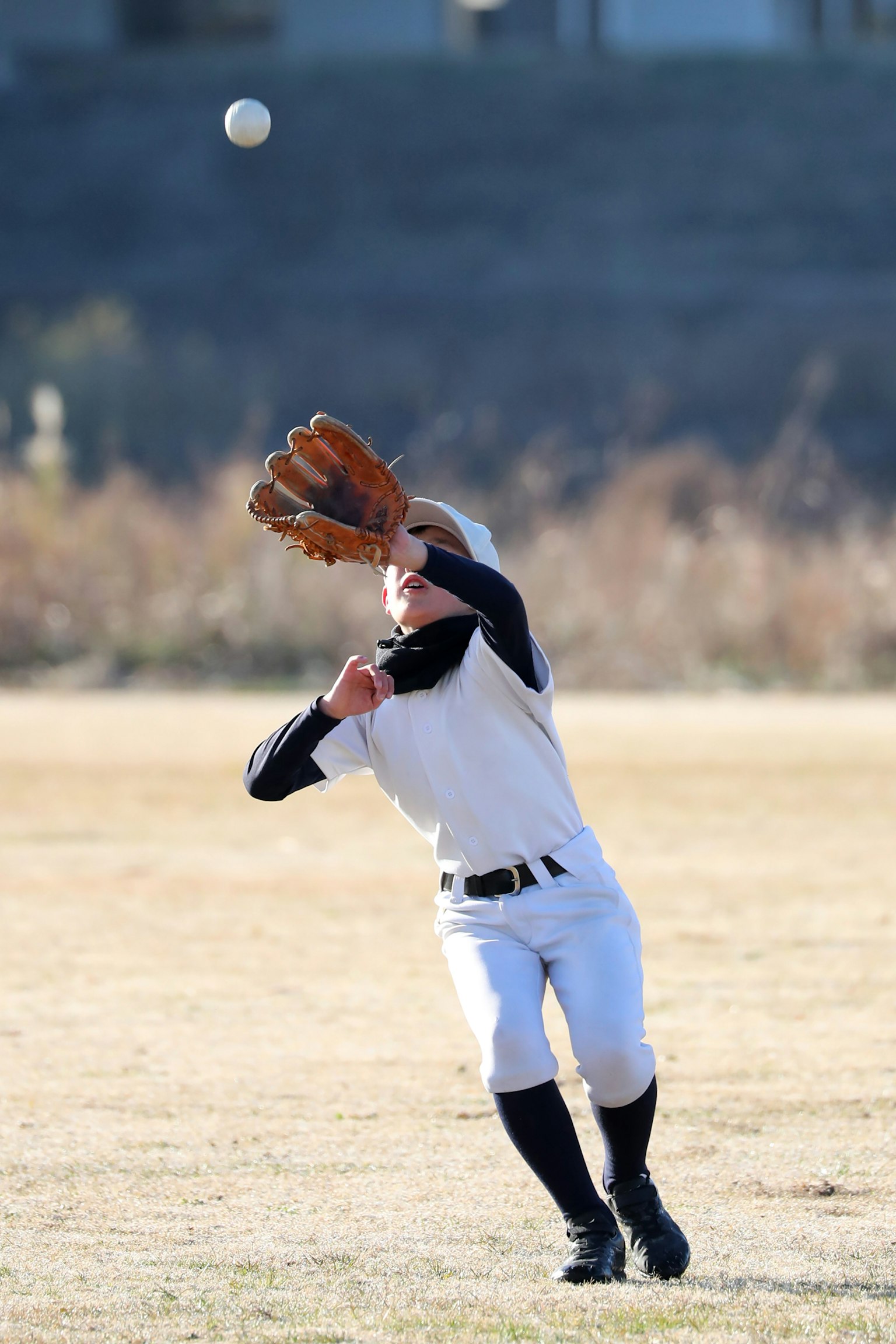 Un ragazzo sta cercando di prendere una palla da baseball