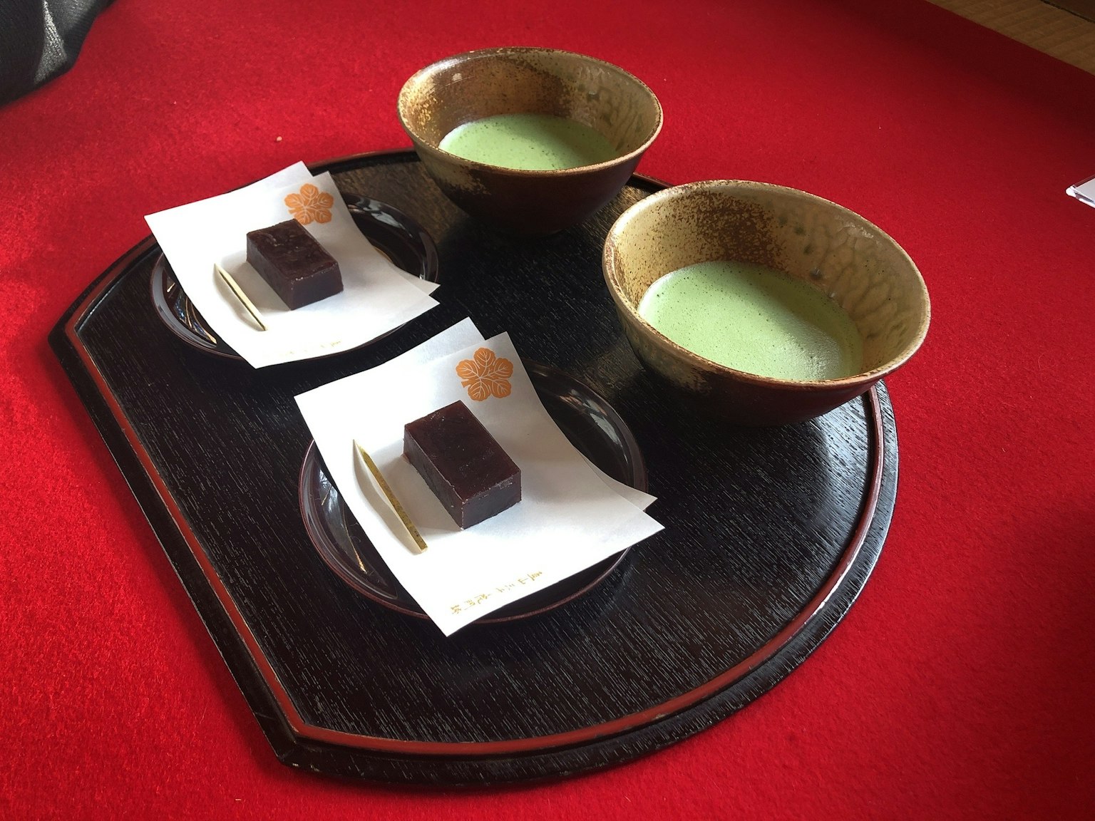 两个碗的抹茶茶和甜点放在木托盘上