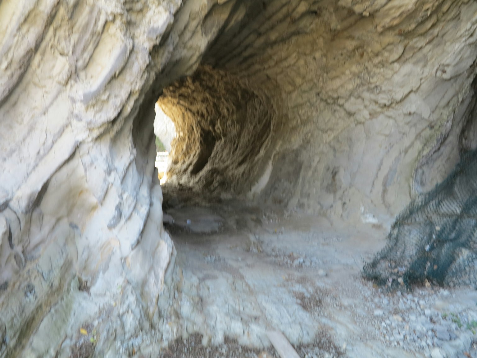 Interior of a rock tunnel with light shining through