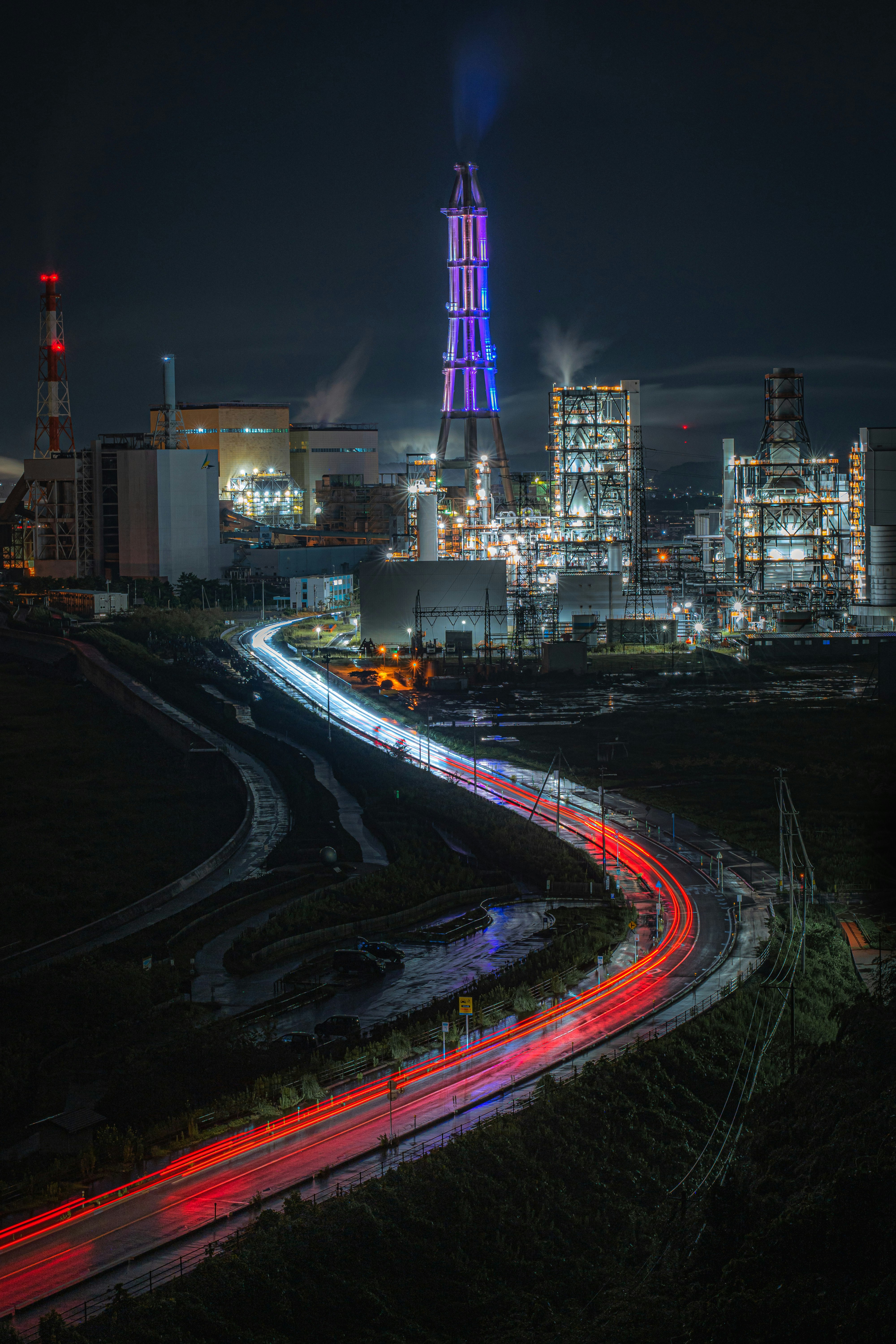 夜景の工業地帯と高速道路の光跡