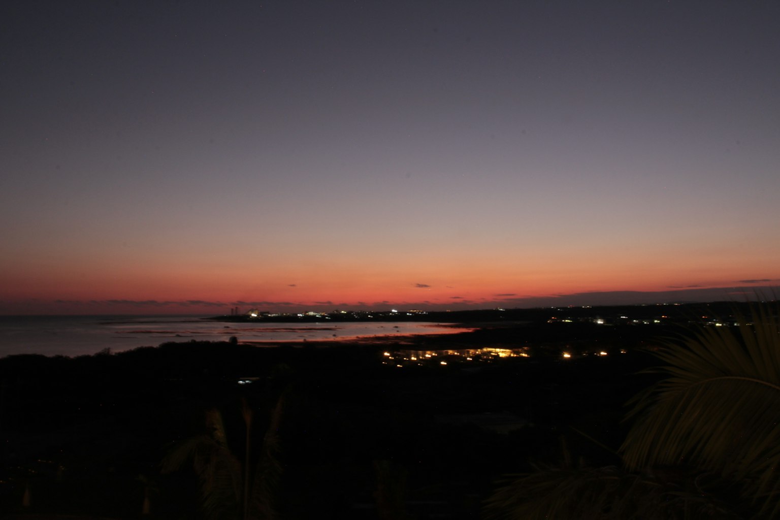 Vue côtière pittoresque au coucher du soleil avec des lumières de la ville
