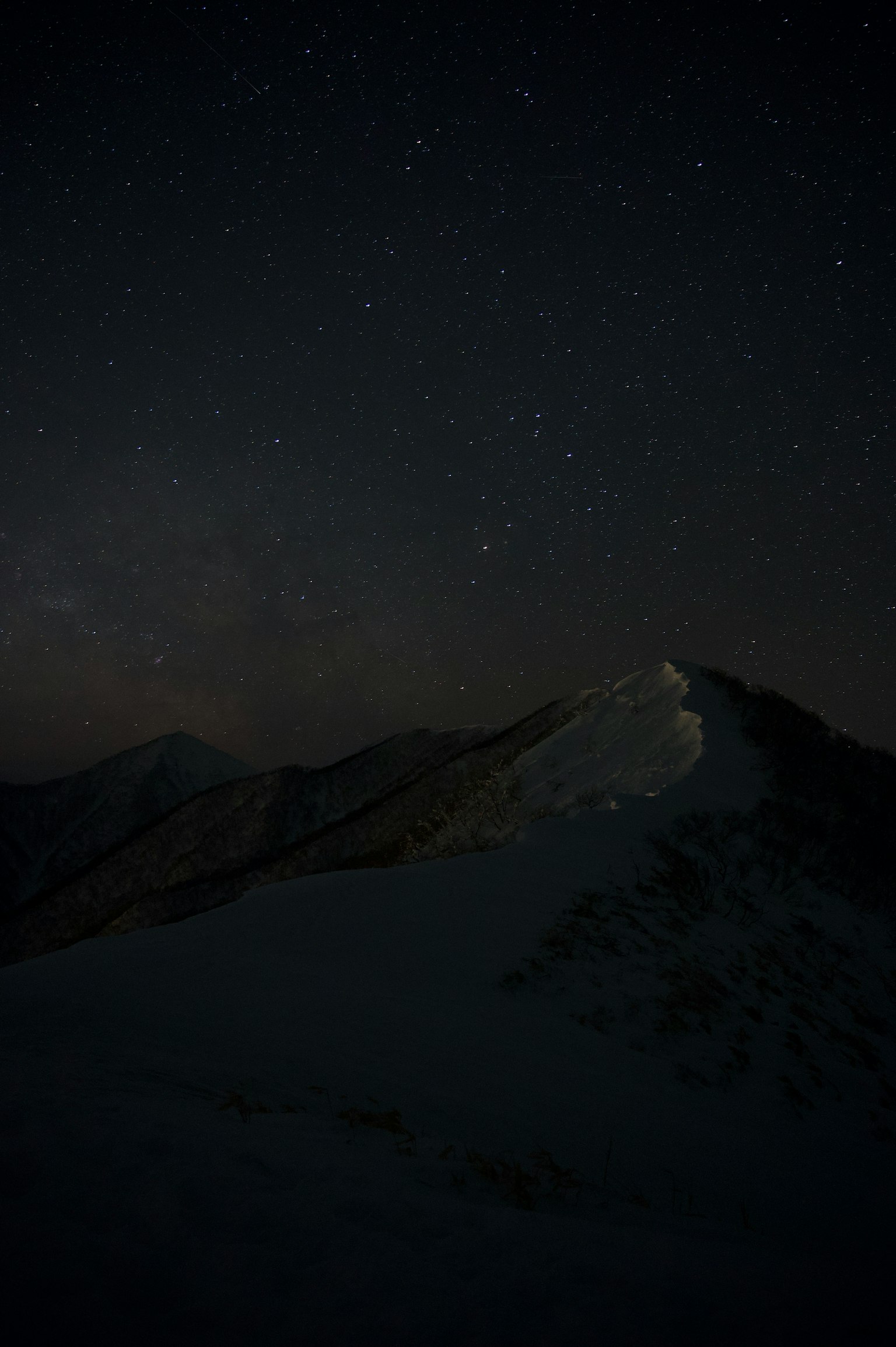 Cielo notturno stellato con silhouette di montagna