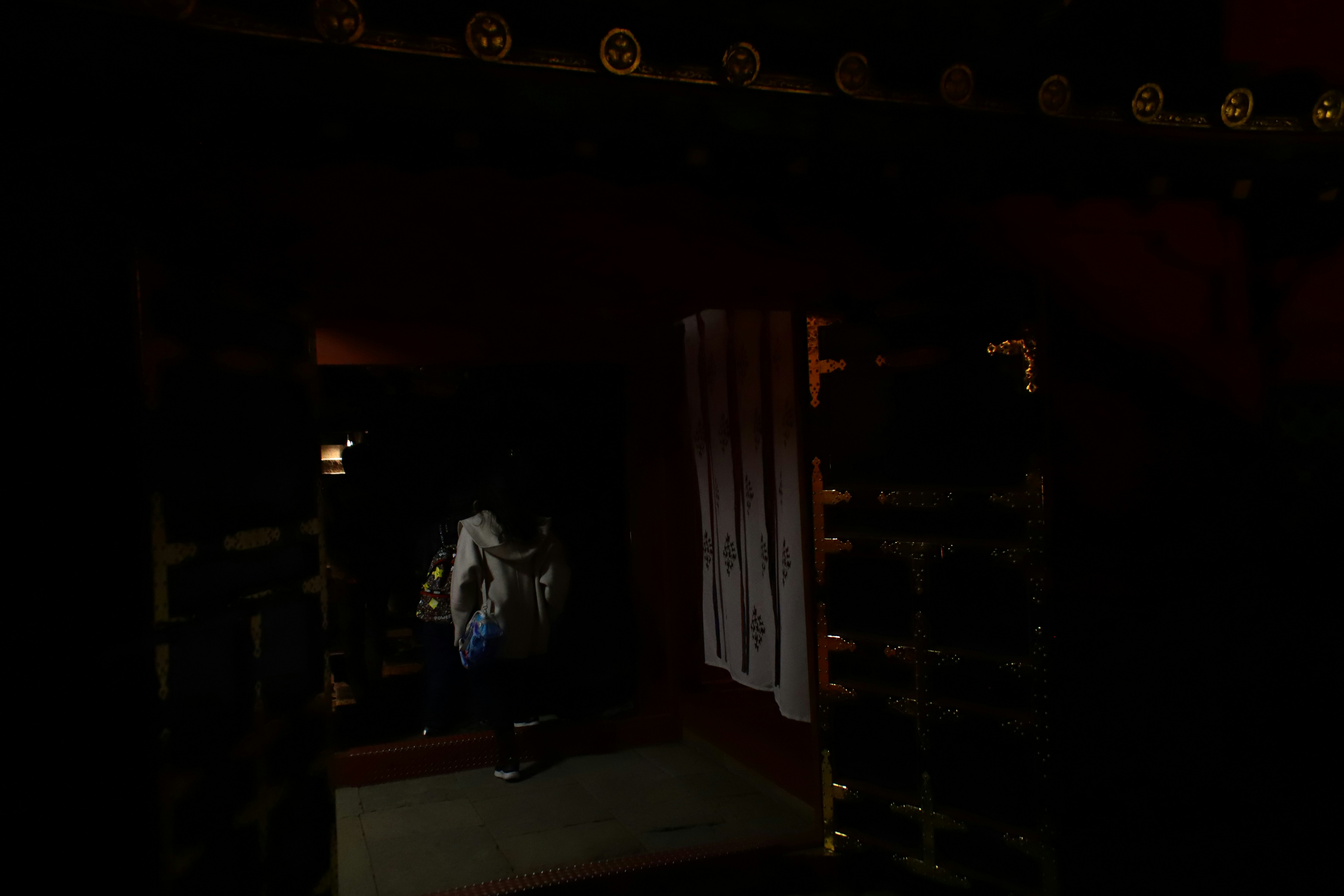 ruelle sombre avec une lumière qui s’infiltre et une silhouette au loin
