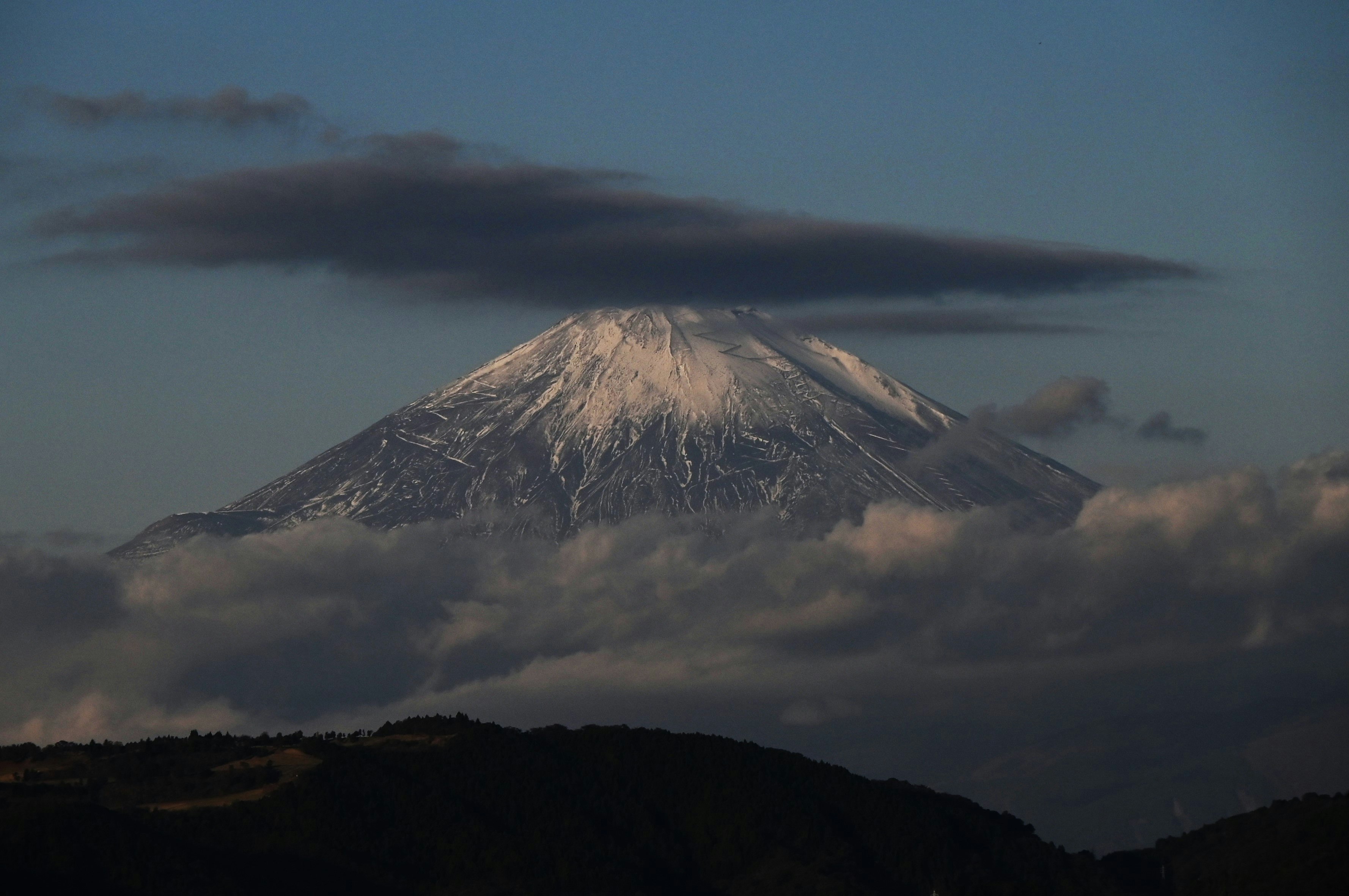 silhouette de montagne enveloppée de nuages au crépuscule