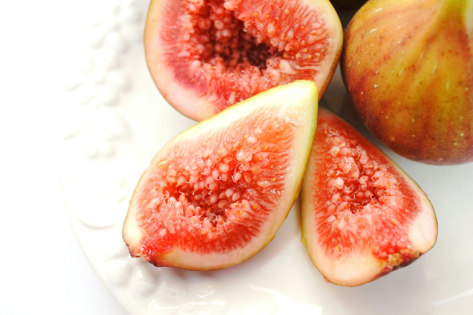 Sliced figs displayed on a white plate