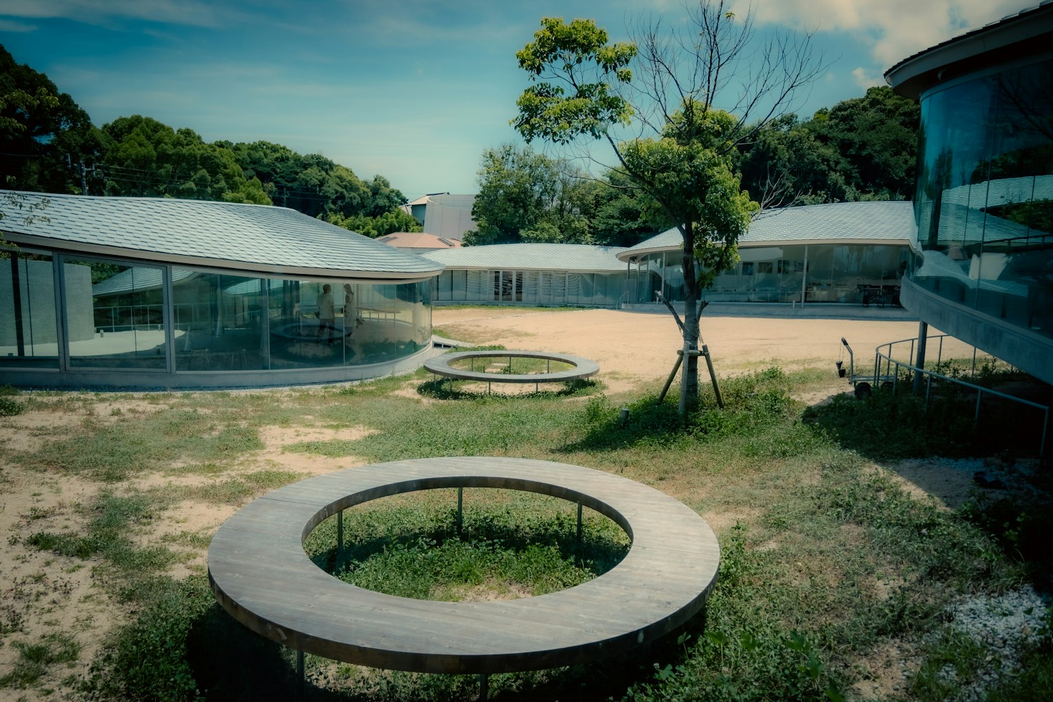 现代建筑空间，带有圆形长椅和草地区域