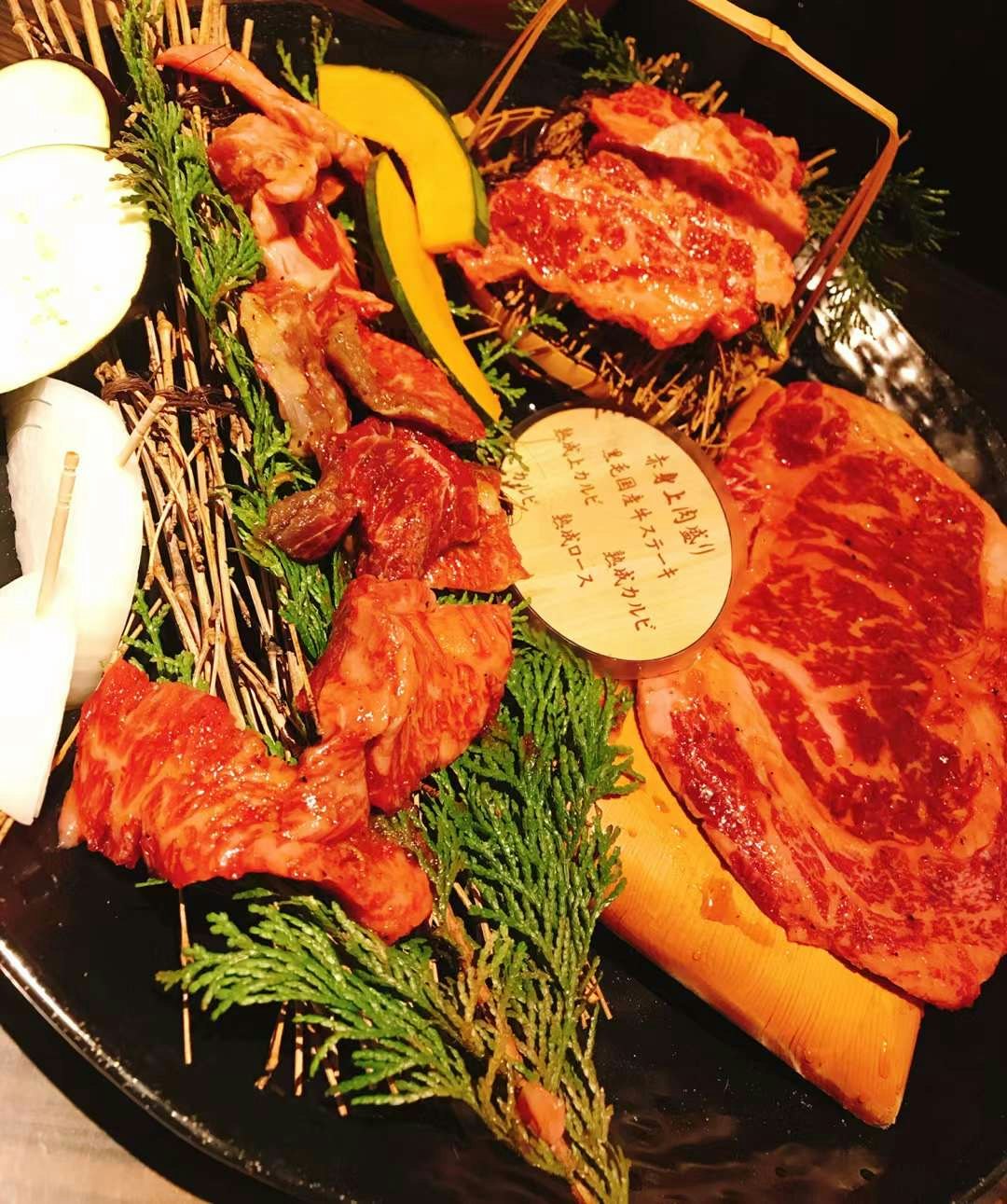assorted grilled meats and vegetables on a hot plate