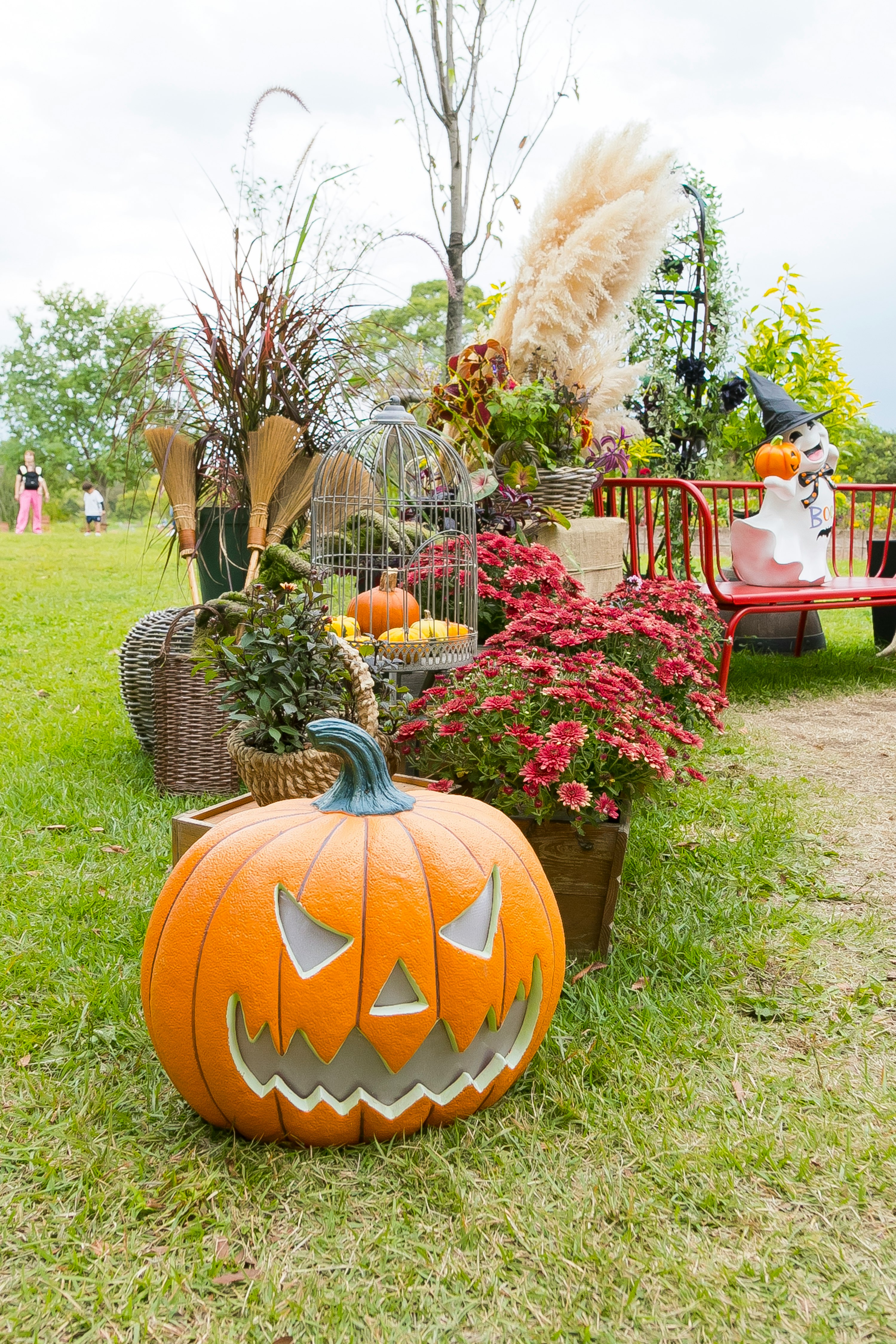 outdoor Halloween-style pumpkin and flower decorations on a lawn