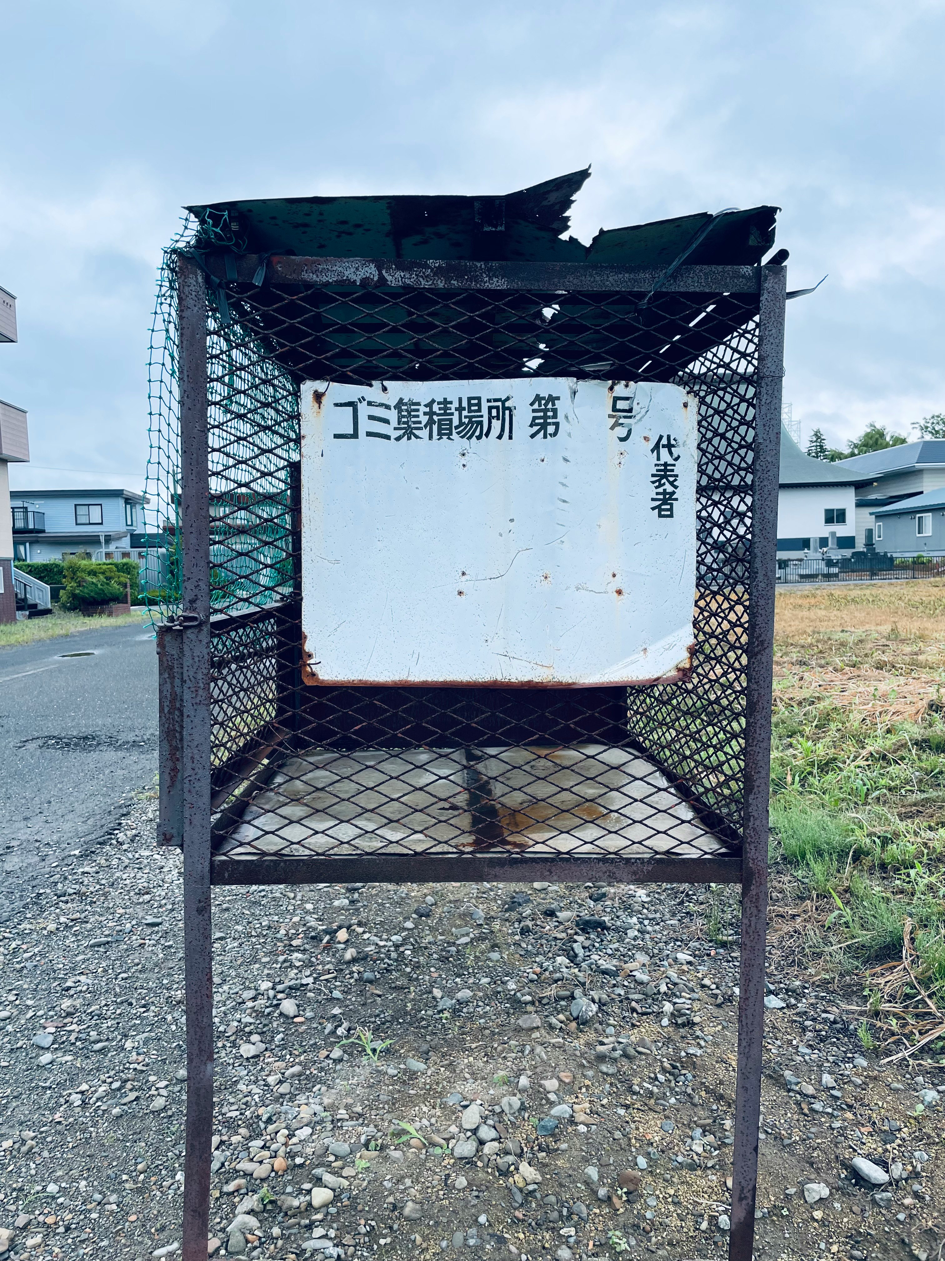 ゴミ集積場所の鉄のカゴと掲示板