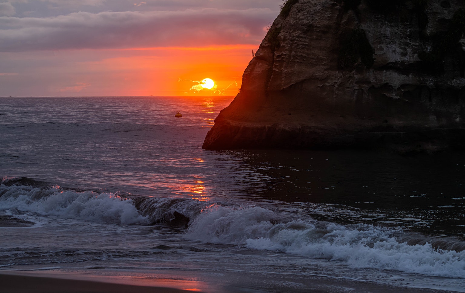 Magnifique coucher de soleil sur l'océan avec silhouette de la côte et des rochers