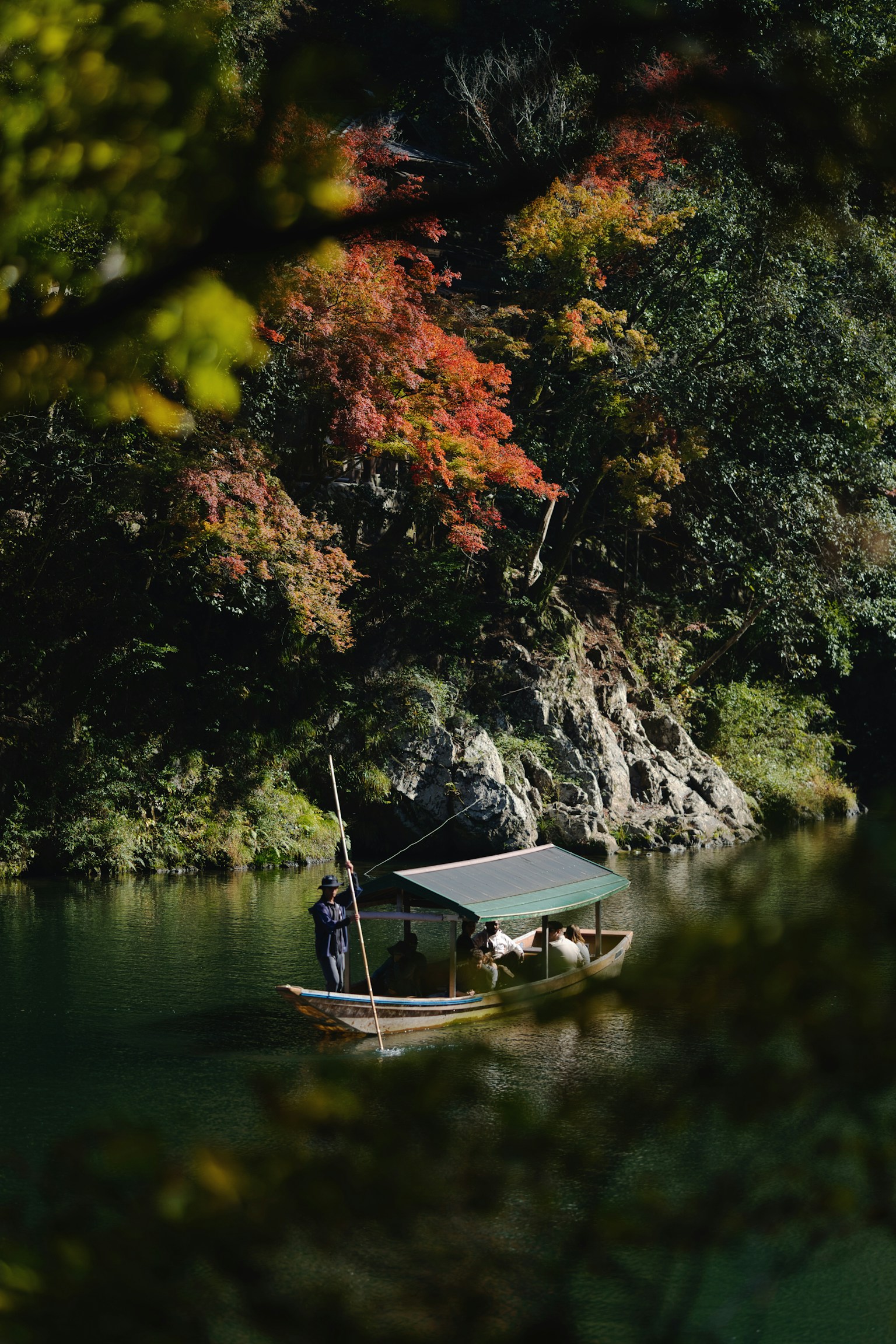 A small boat on a river surrounded by autumn foliage