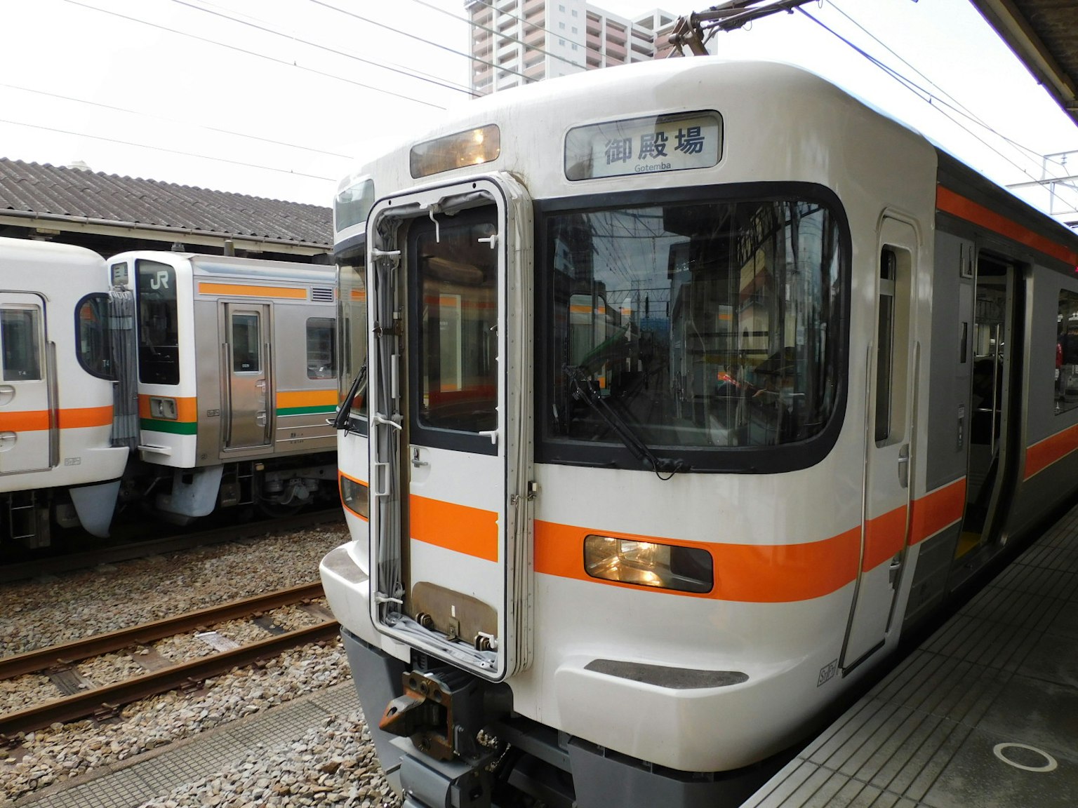 Japanese train with distinctive orange stripes parked at a station