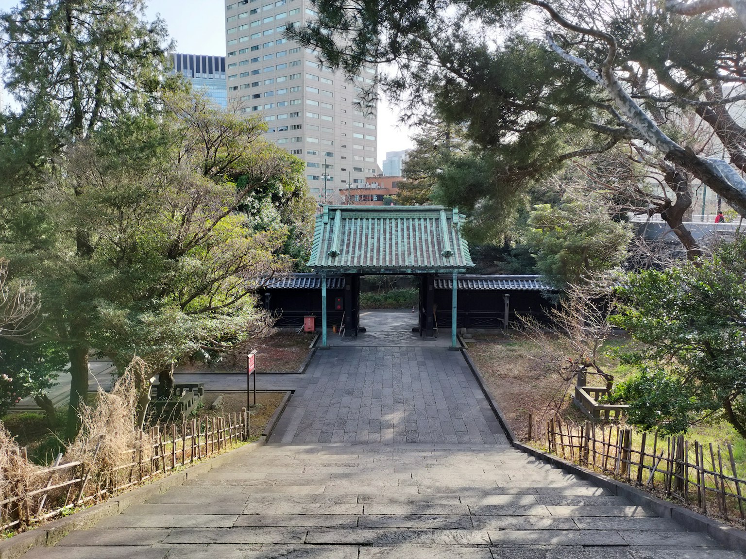 Traditionelles japanisches Tor in einem Park umgeben von Grün