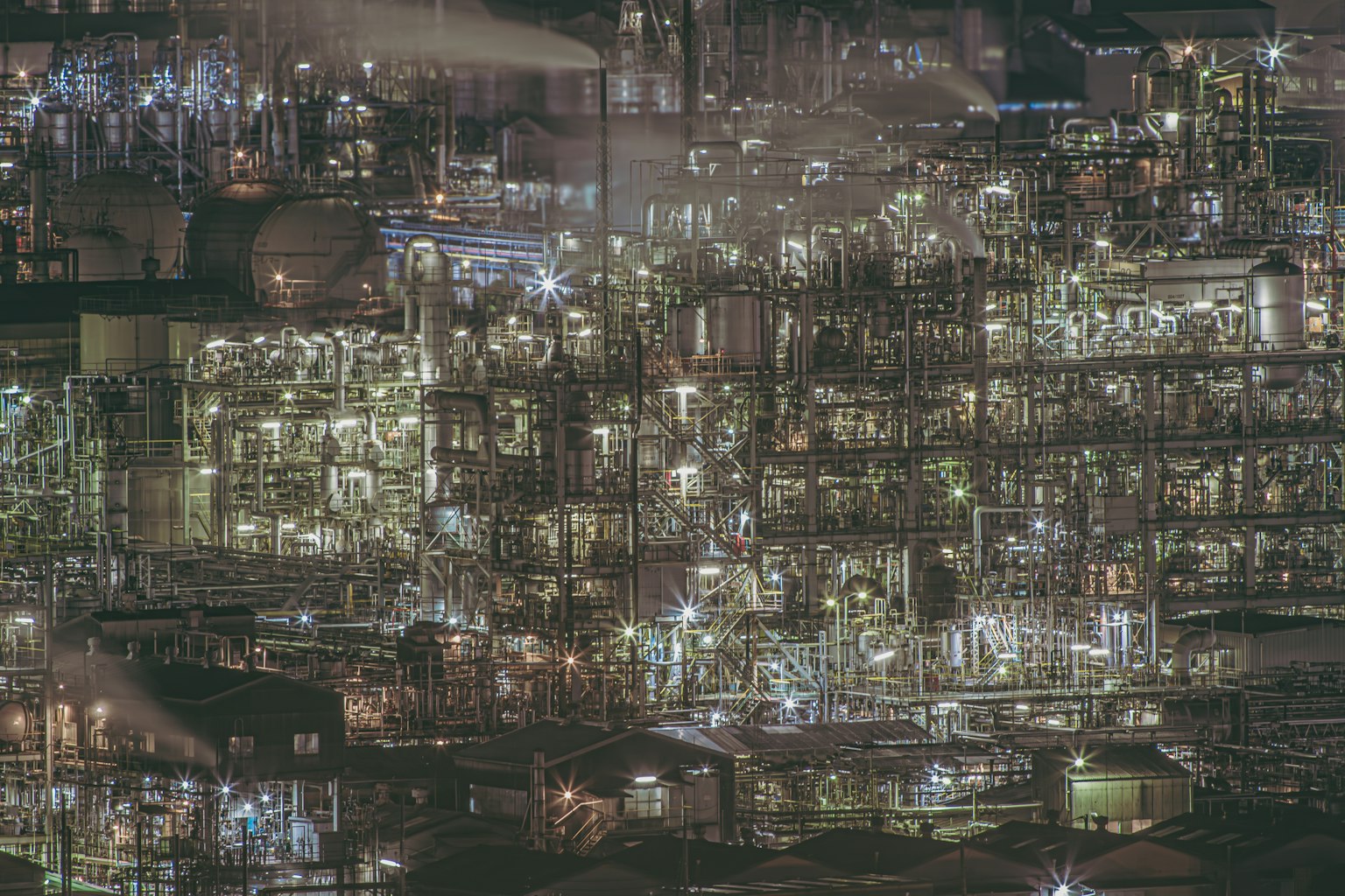 Illuminated industrial plant at night showcasing complex structures