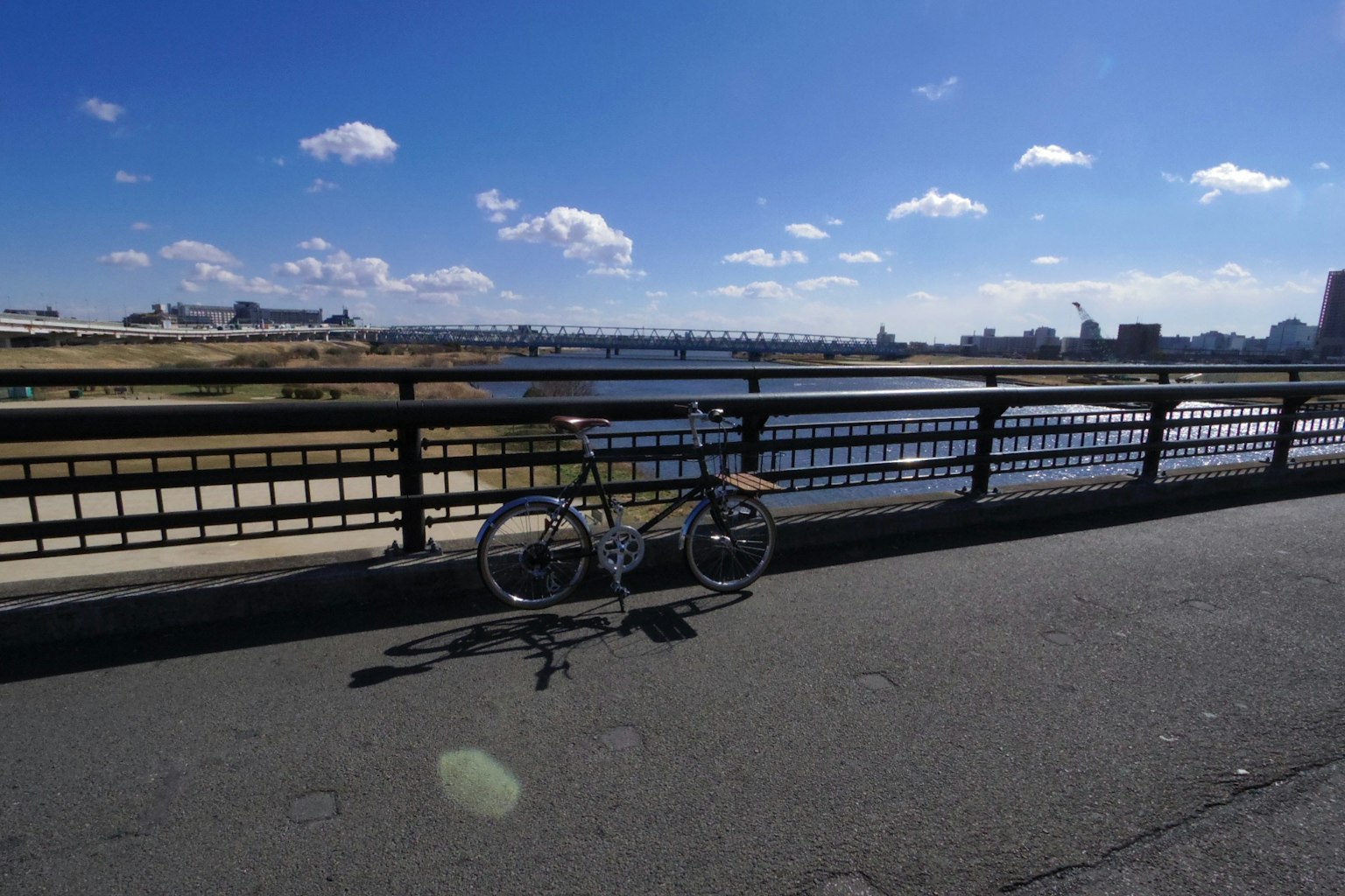 Bicicletta parcheggiata accanto a un fiume sotto un cielo blu