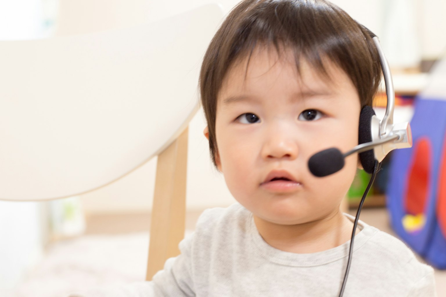 Trẻ nhỏ đeo tai nghe nhìn về phía camera