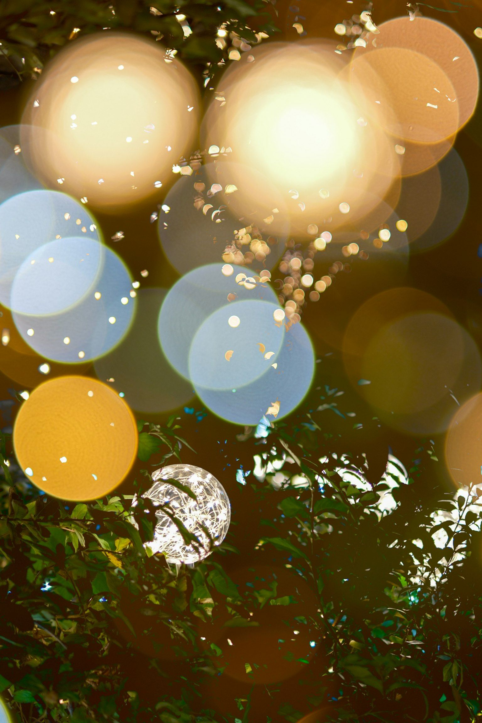 Schöner Hintergrund mit verschwommenen Lichtpunkten und grünen Blättern