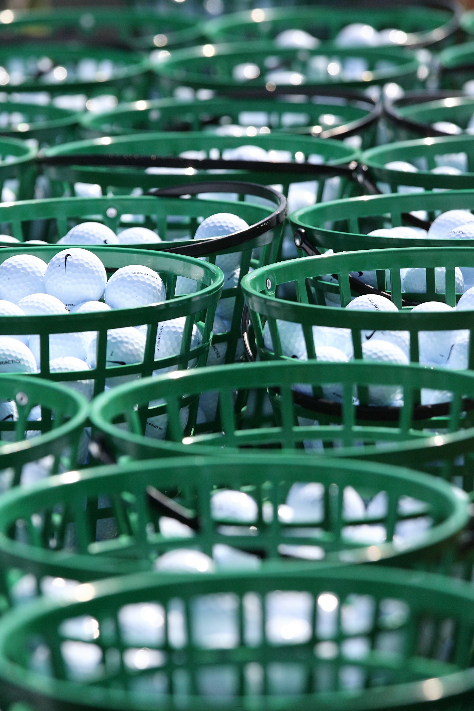 Bolas de golf blancas organizadas en canastas verdes