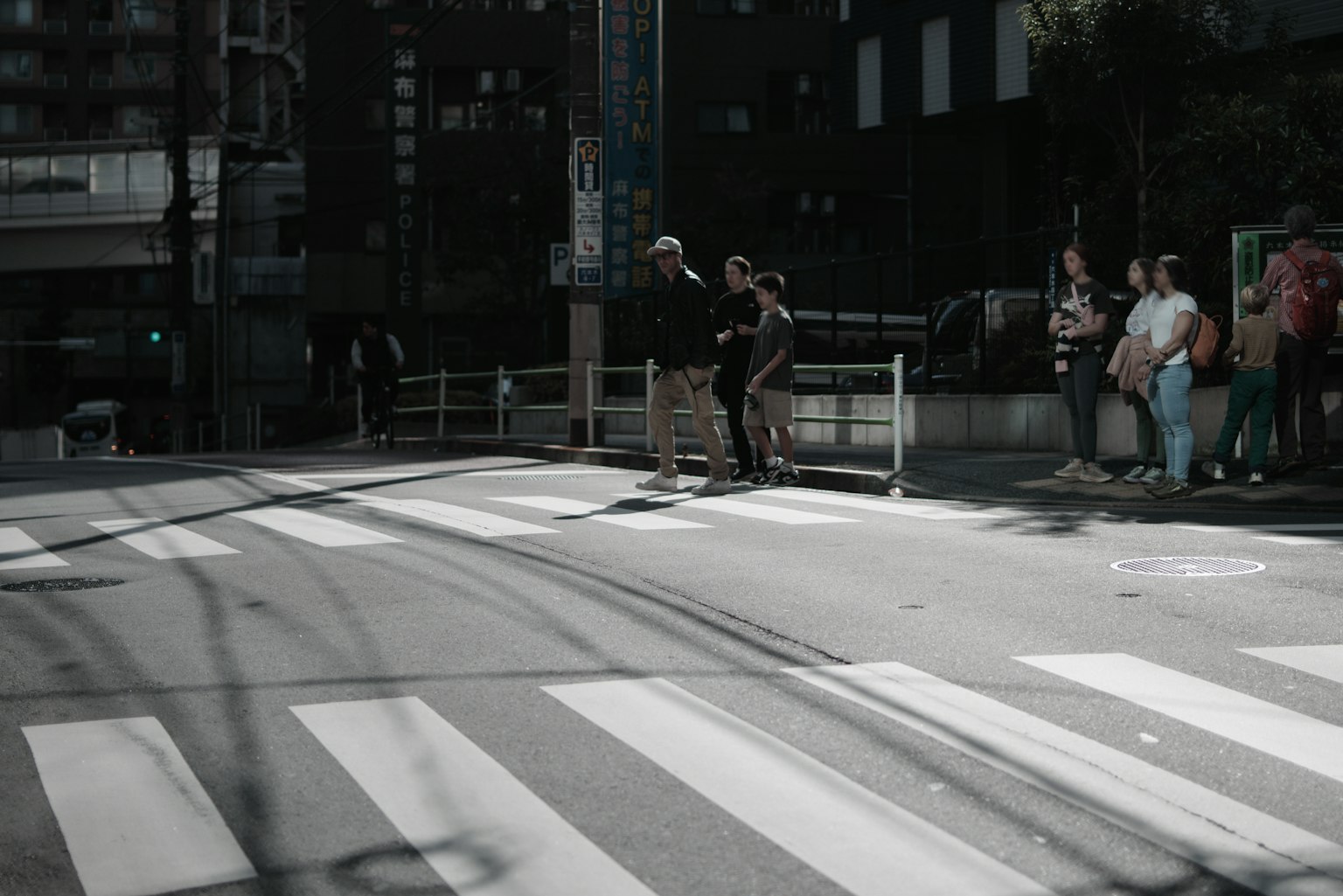 城市場景，人們在斑马線等候，年輕人享受街頭藝術