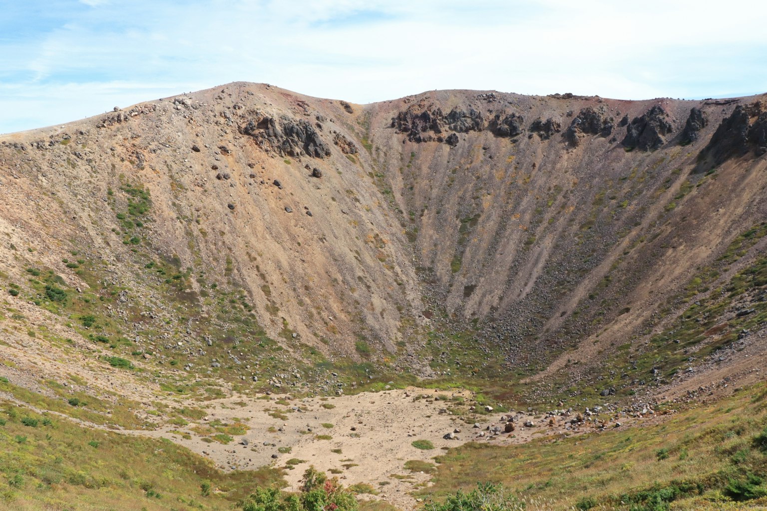 Vulkanischer Kraterlandschaft mit Gras und felsigem Gelände
