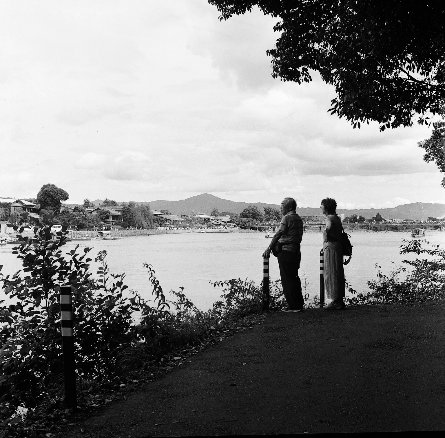 สองคนมองไปที่แม่น้ำพร้อมภูมิทัศน์ที่สวยงาม