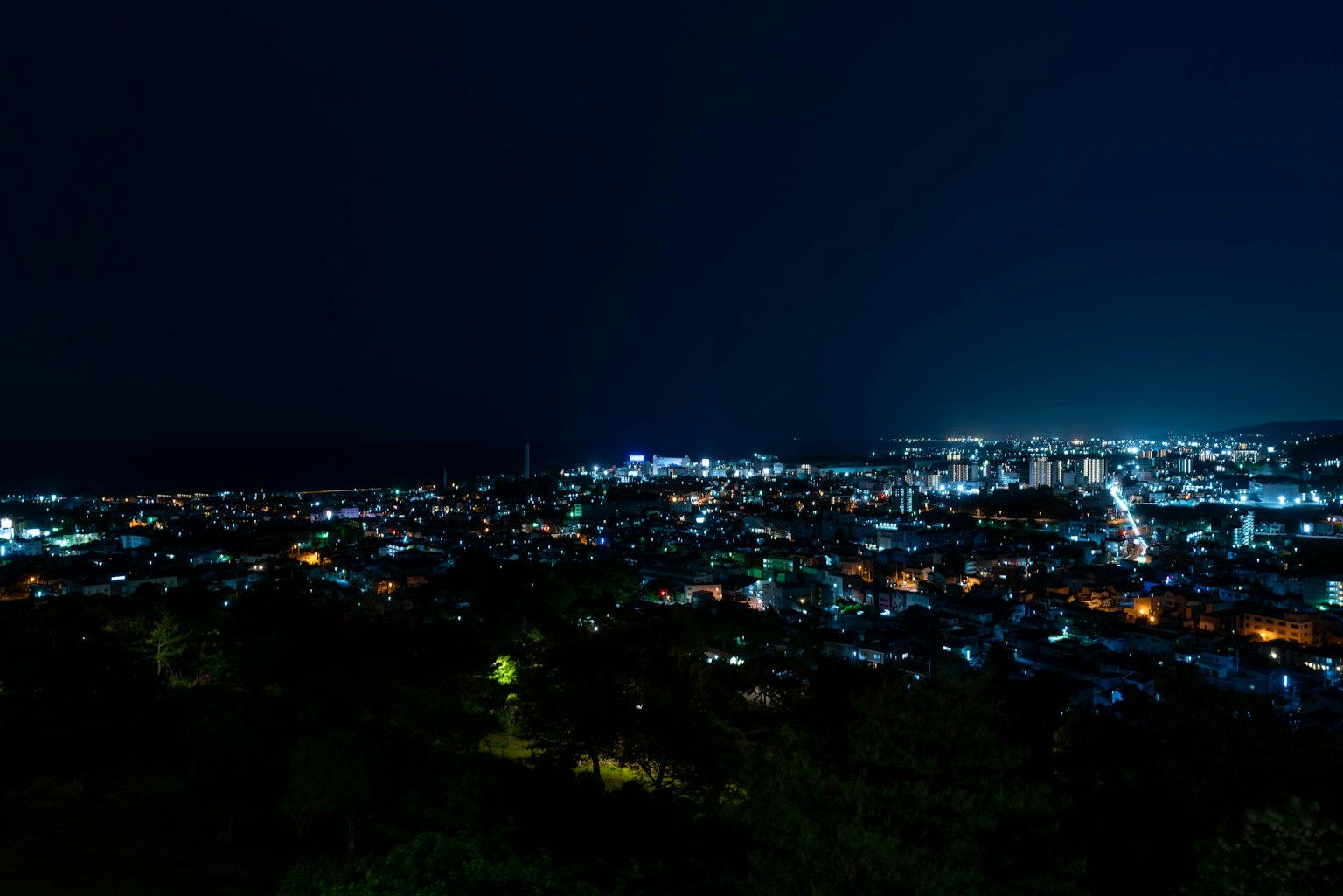 Pemandangan kota malam dengan lampu jalan dan gedung yang diterangi