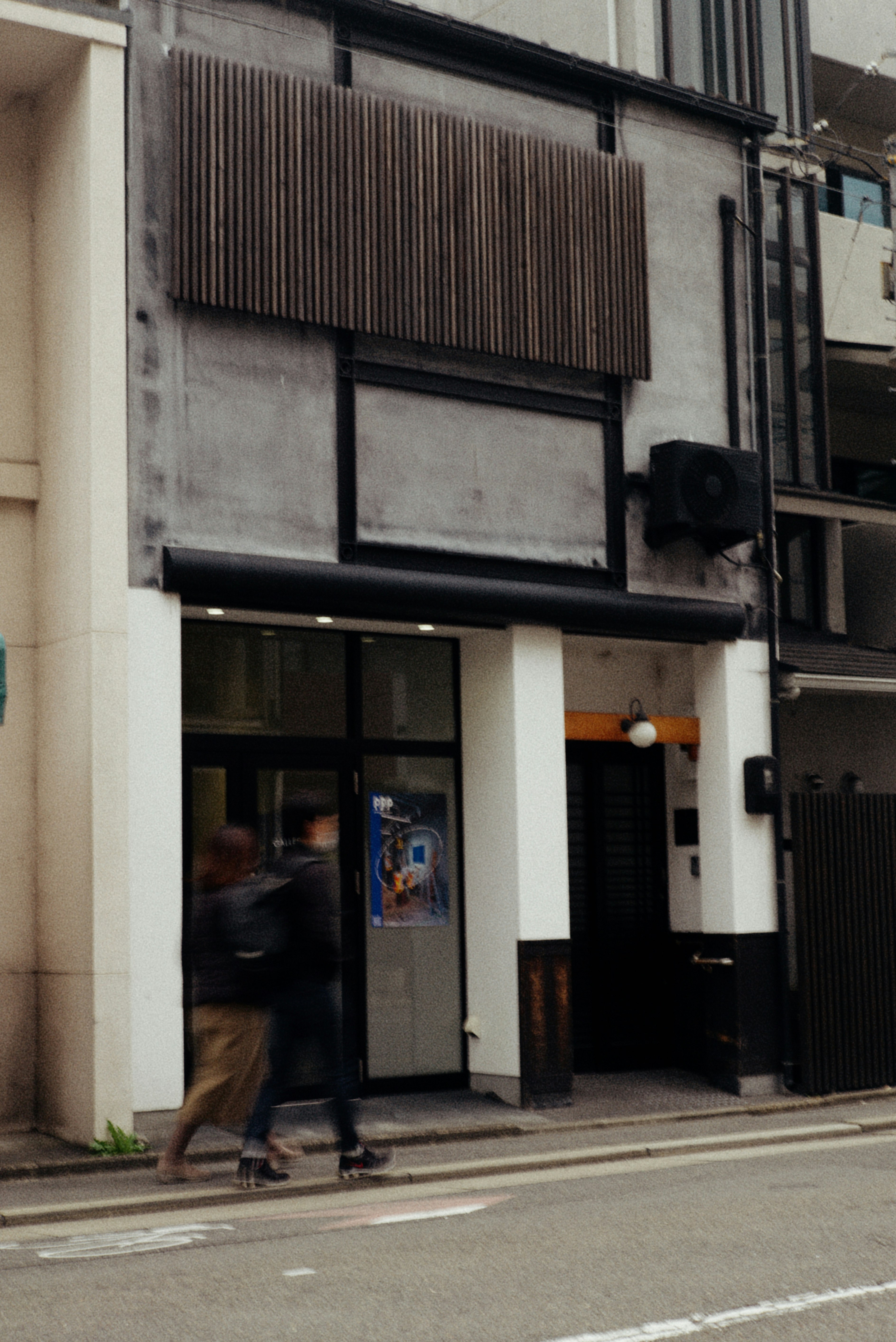 京都の路地に面した店舗の外観と通りの人影