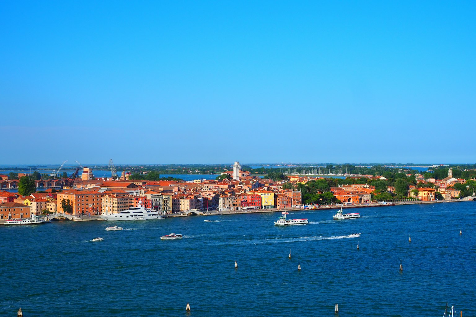 Colorful buildings and boats under a blue sky in Venice