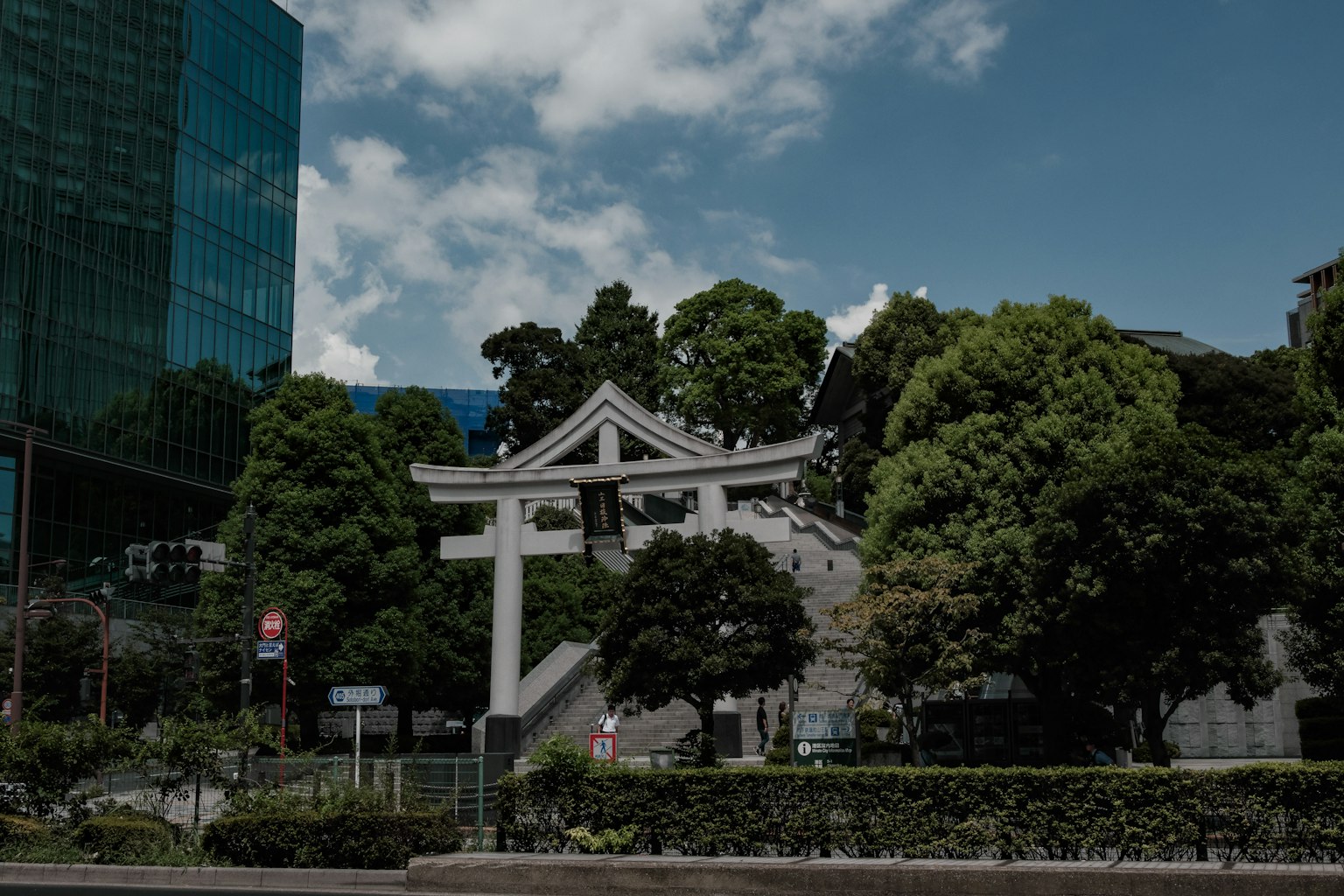 Torii-Tor in städtischer Umgebung umgeben von üppigem Grün