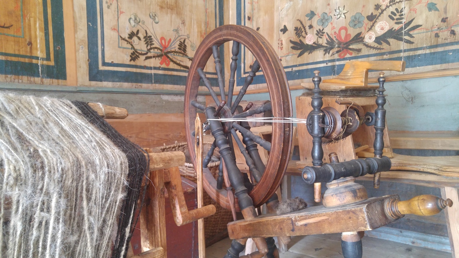 Interior view featuring an antique wooden spinning wheel