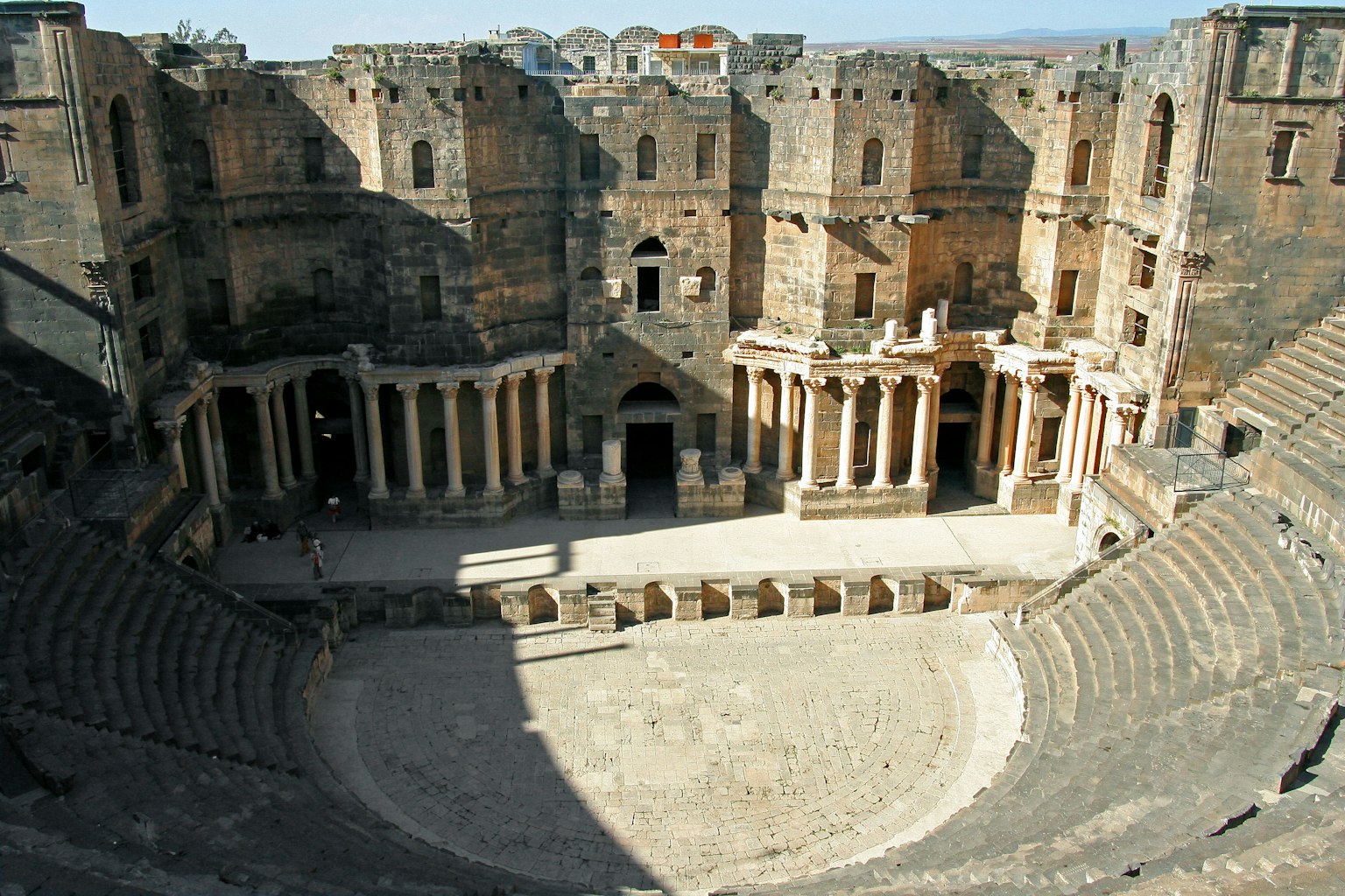 Interior view of an ancient Roman theater featuring ruins and circular seating