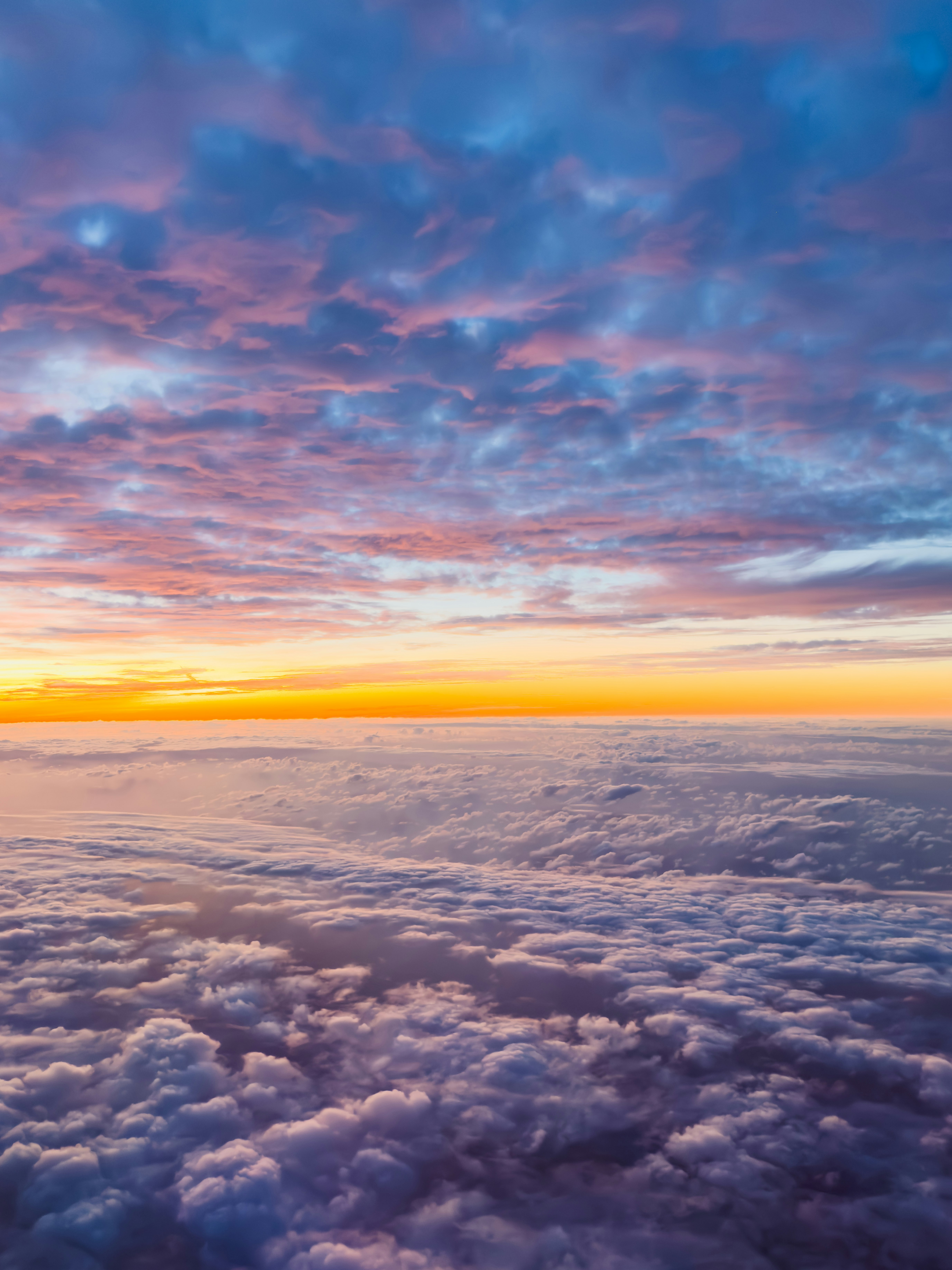 雲の上を飛ぶ航空機と夕焼けの空
