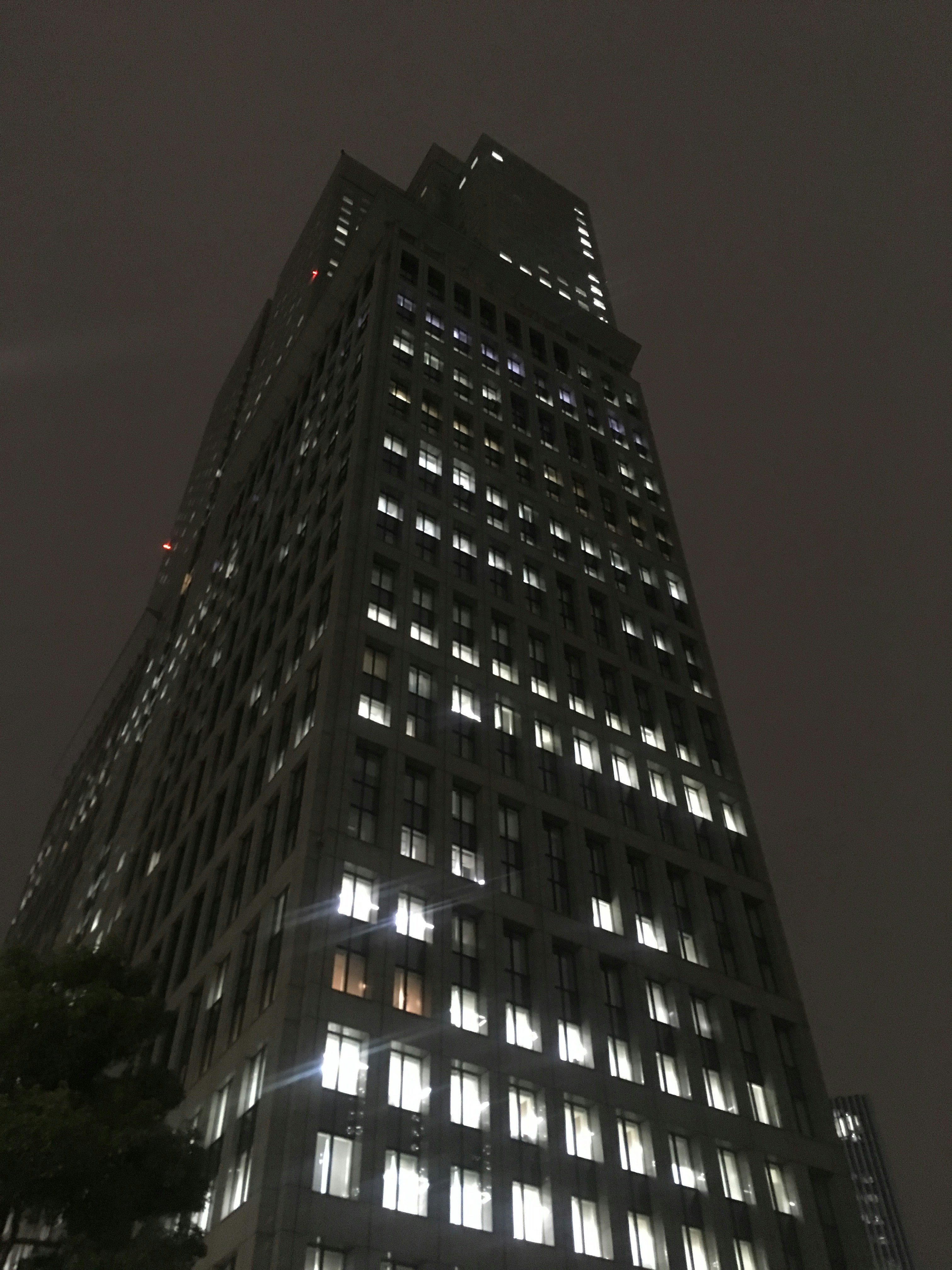 facciata di un grande edificio di notte con finestre illuminate