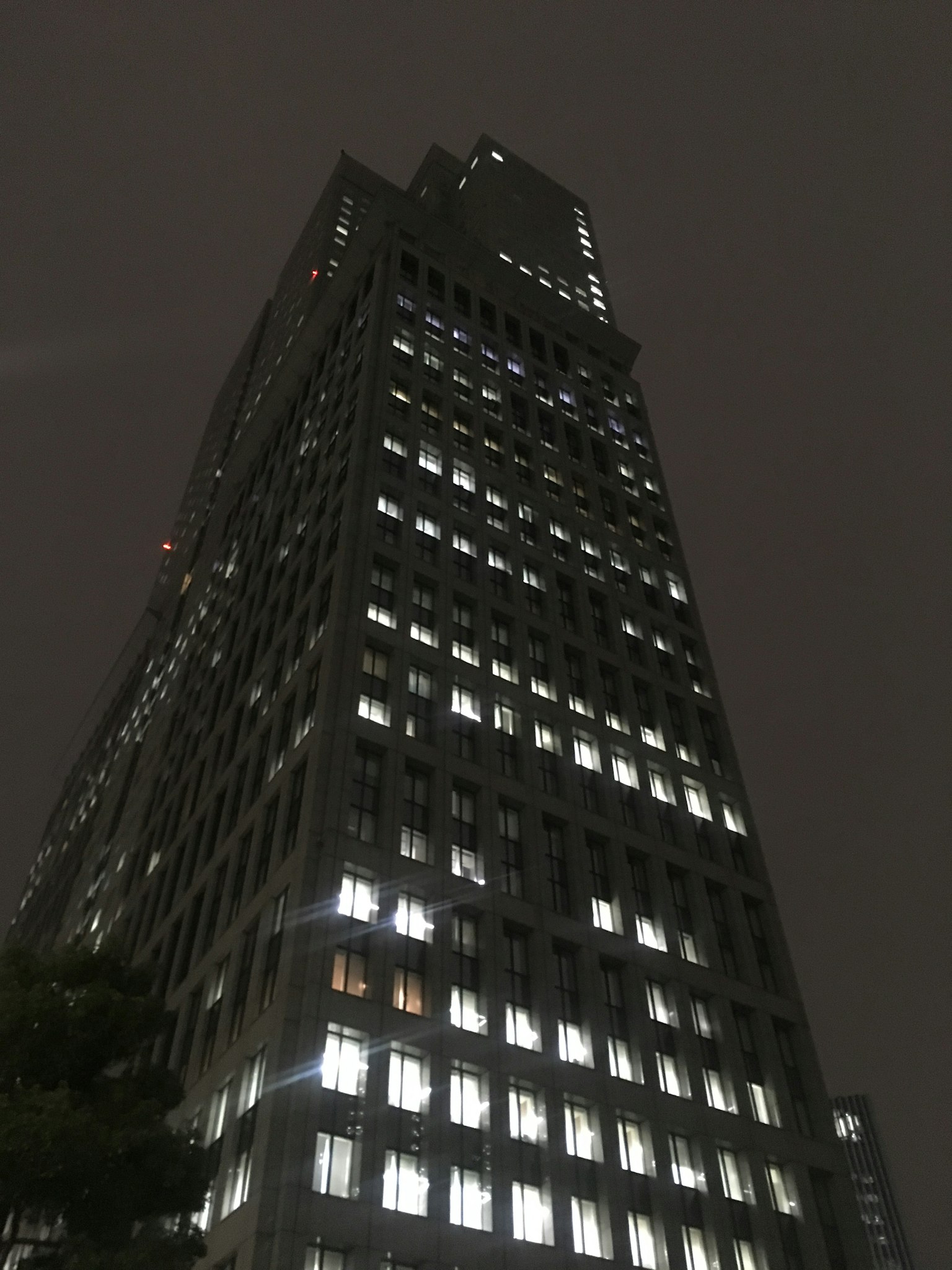 Cảnh đêm của tòa nhà chọc trời với cửa sổ sáng
