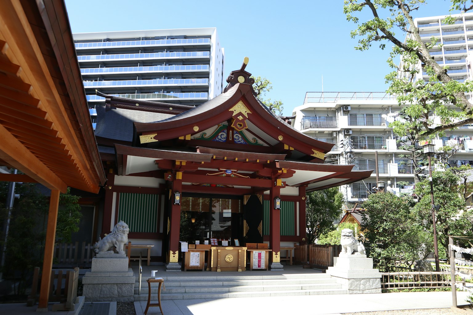 Traditional Shinto shrine architecture contrasted with modern skyscrapers in the background
