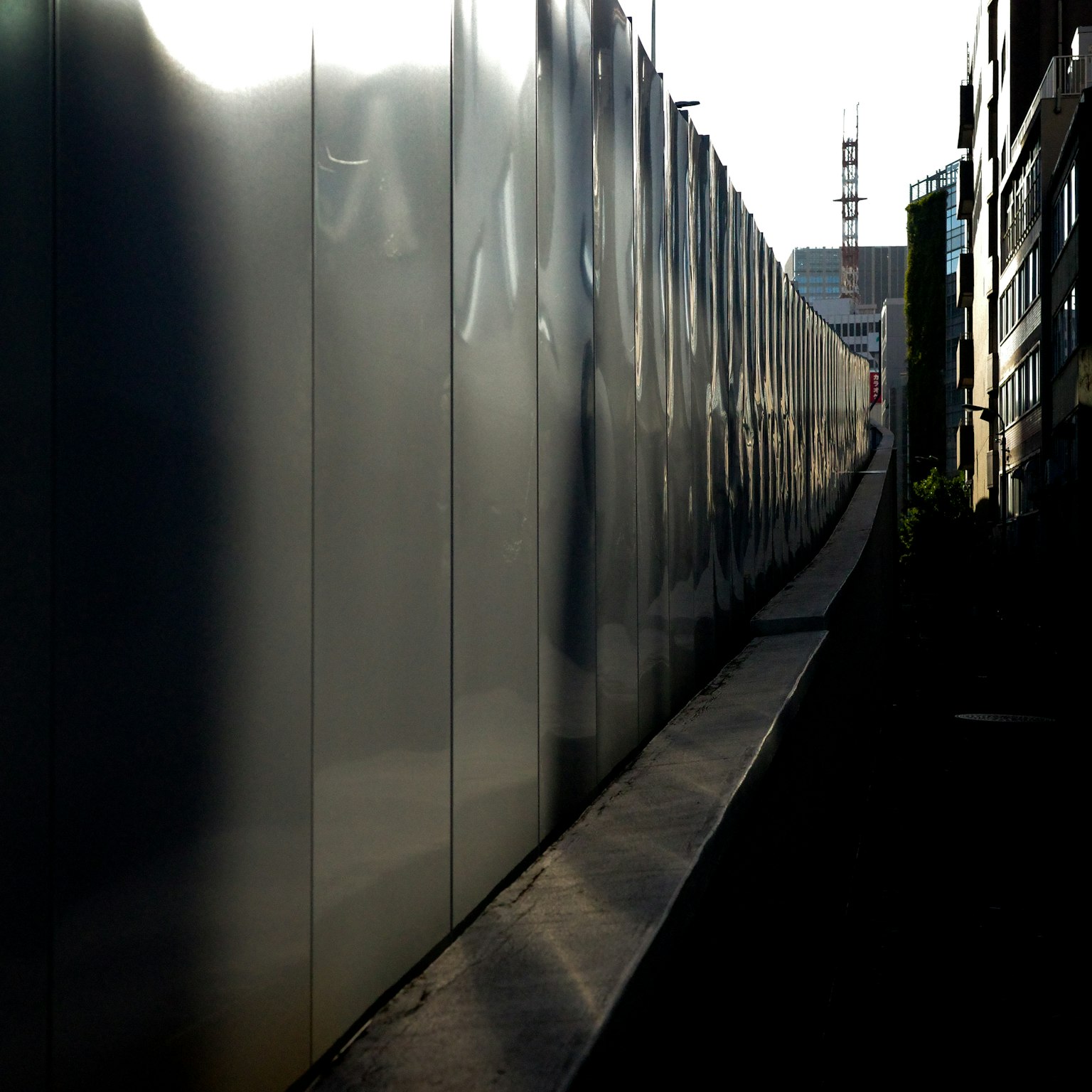 Muro trasparente riflettente con un sentiero in ombra