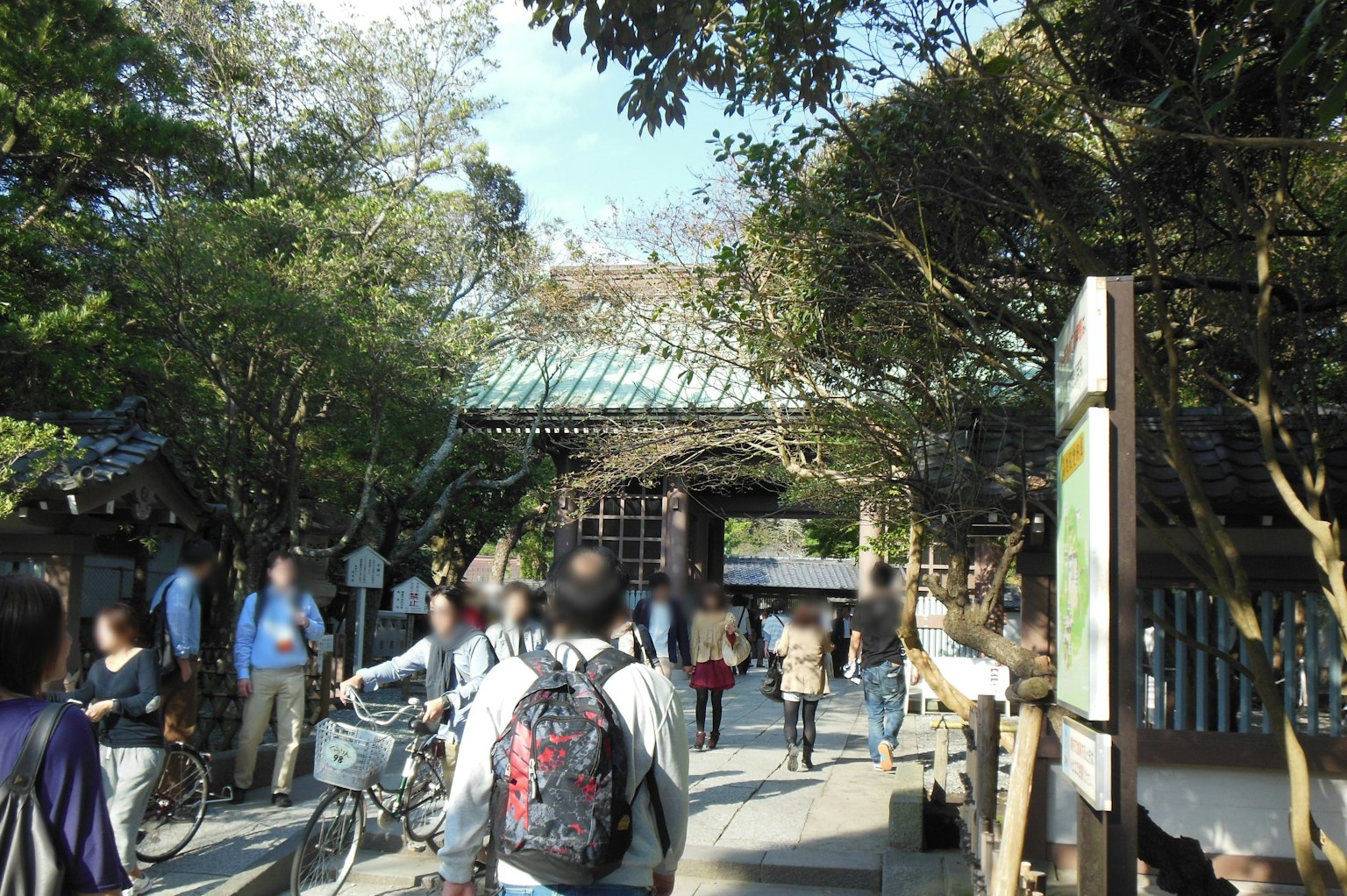 神社入口处热闹的场景，有人和自行车