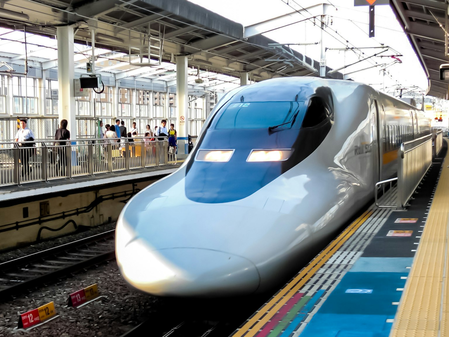 Treno Shinkansen in arrivo alla stazione con passeggeri
