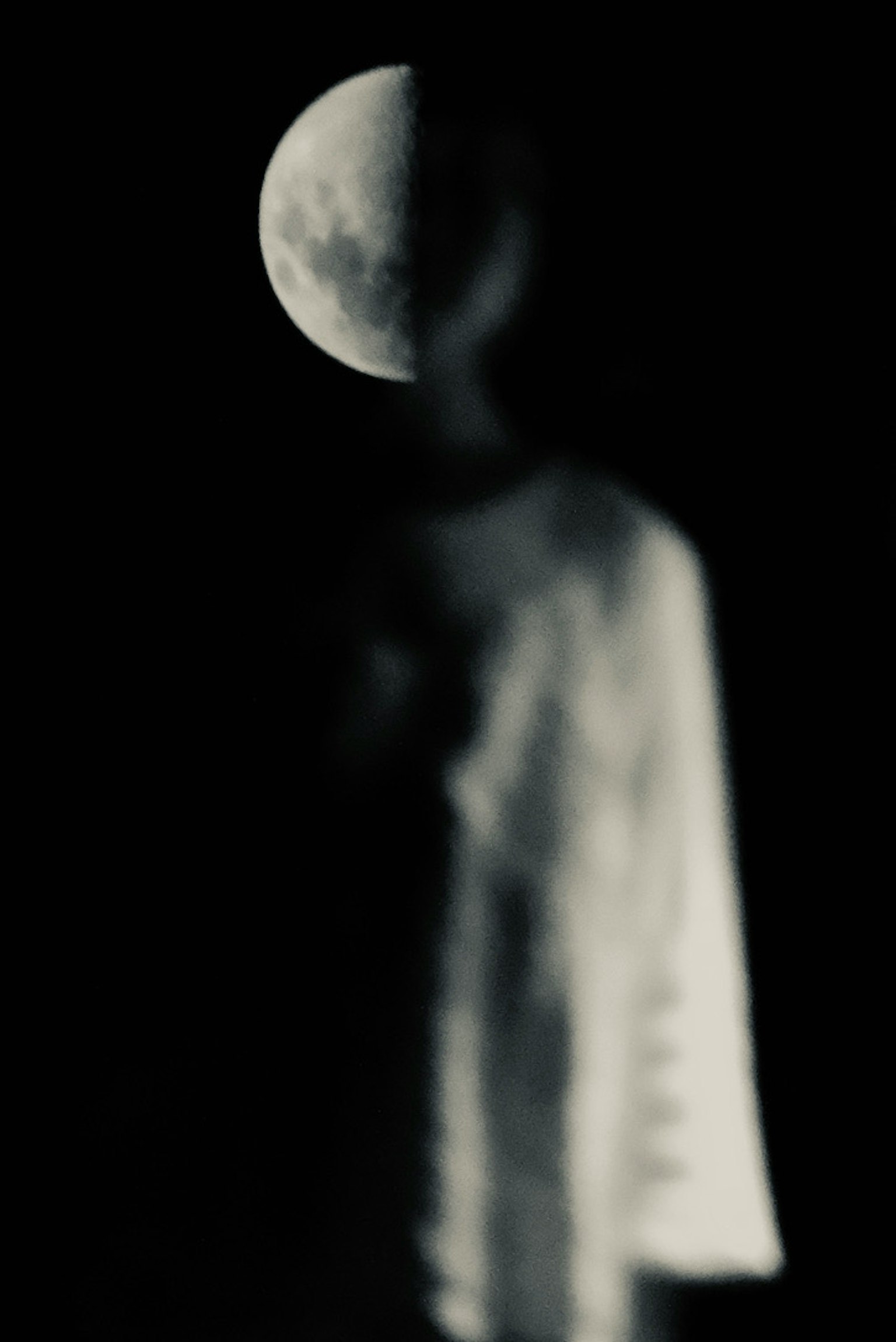 Verschwommene Figur vor einem dunklen Hintergrund mit halb sichtbarem Mond