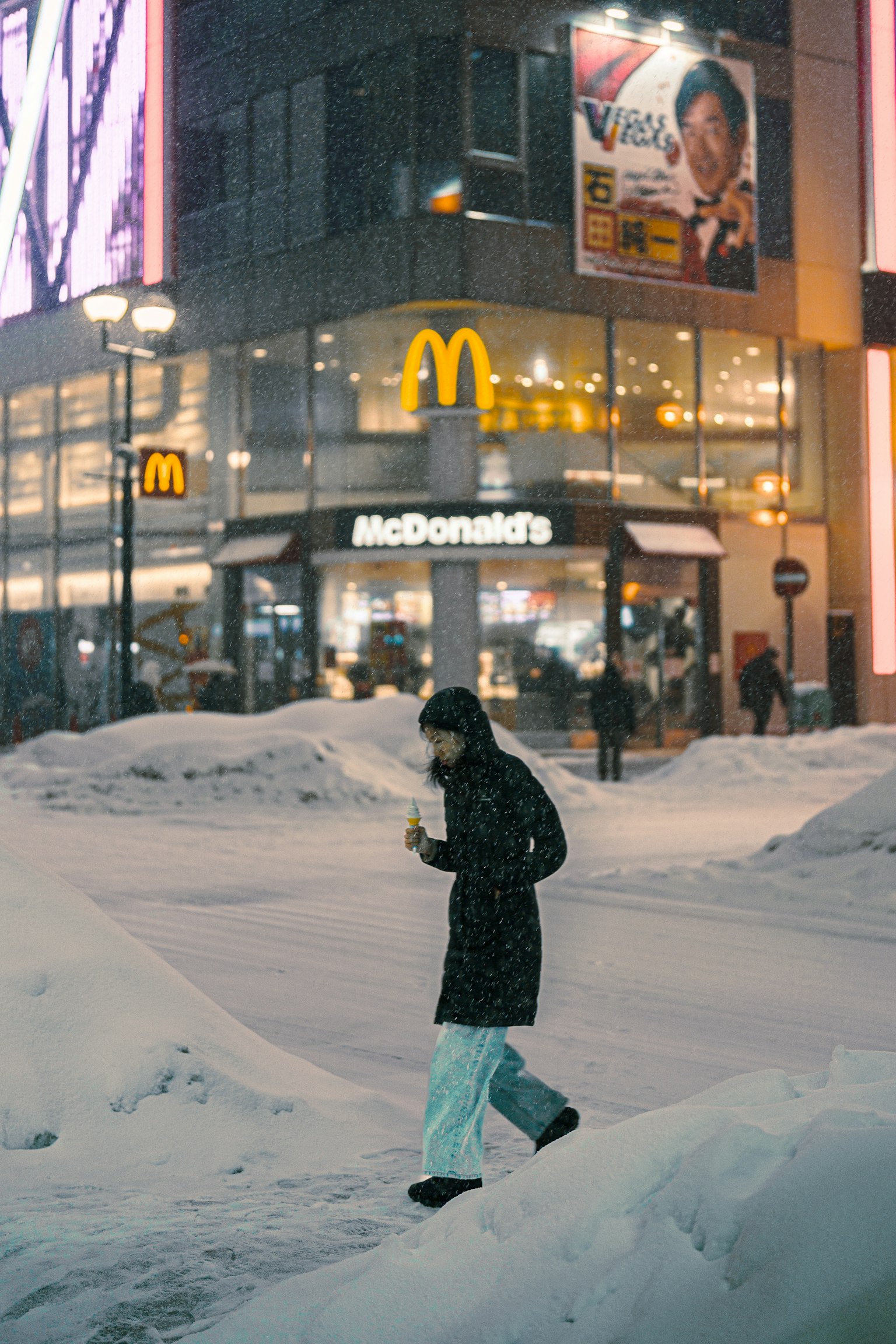 在雪中行走的人和背景中的麥當勞標誌