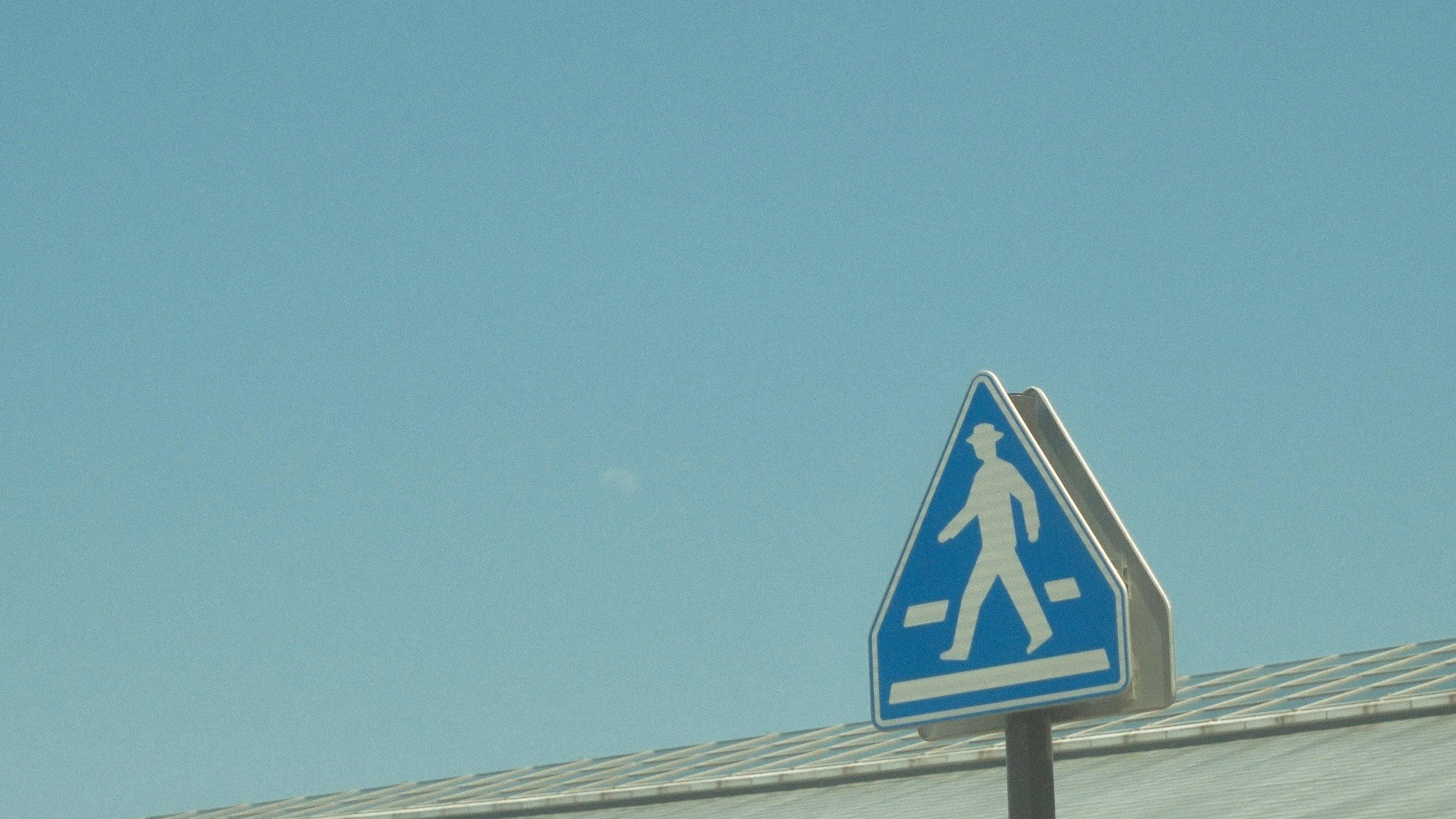 青空の下の横断歩道の歩行者標識