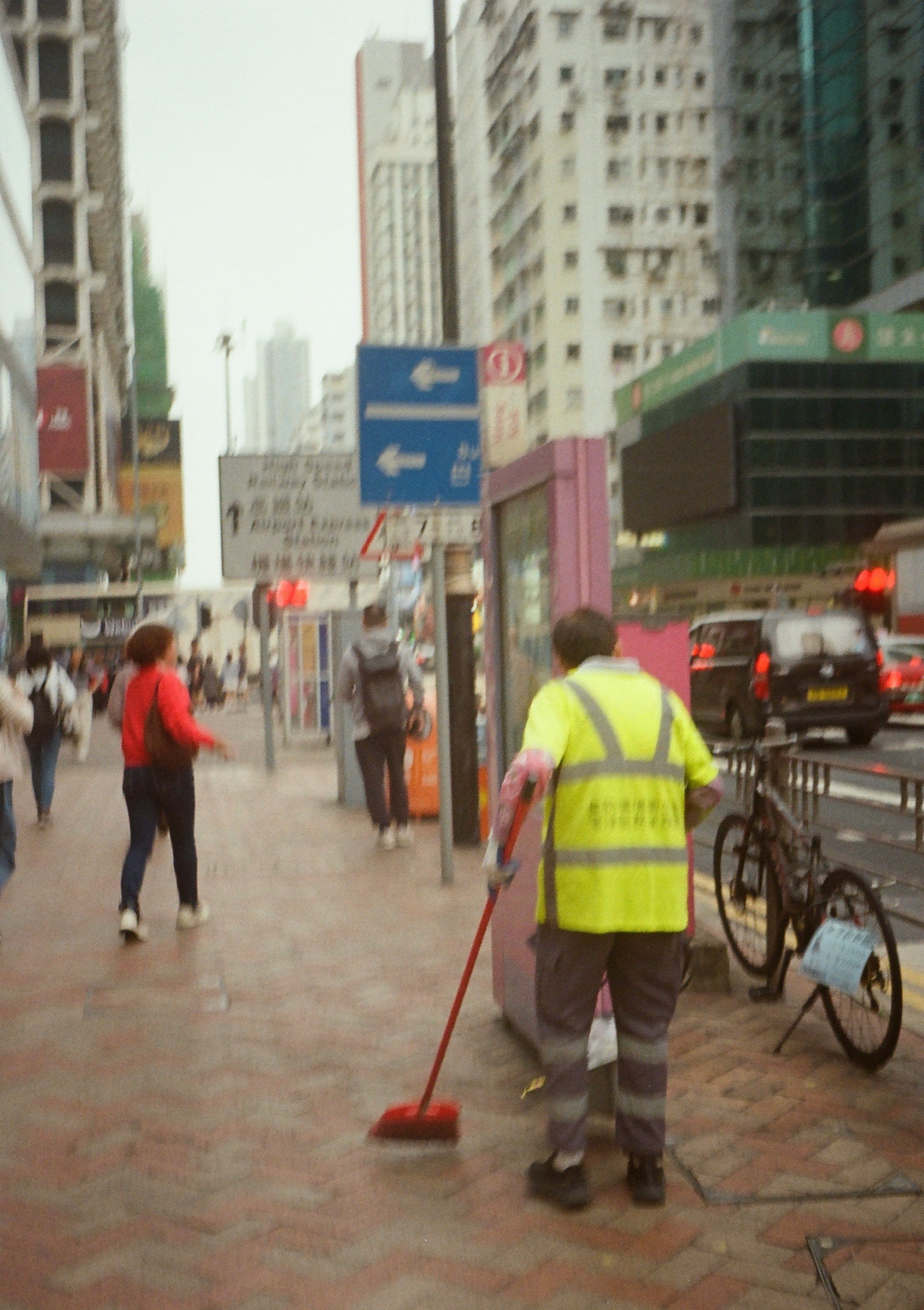 街の清掃作業員が道路を掃除している様子 街の風景と人々が行き交う