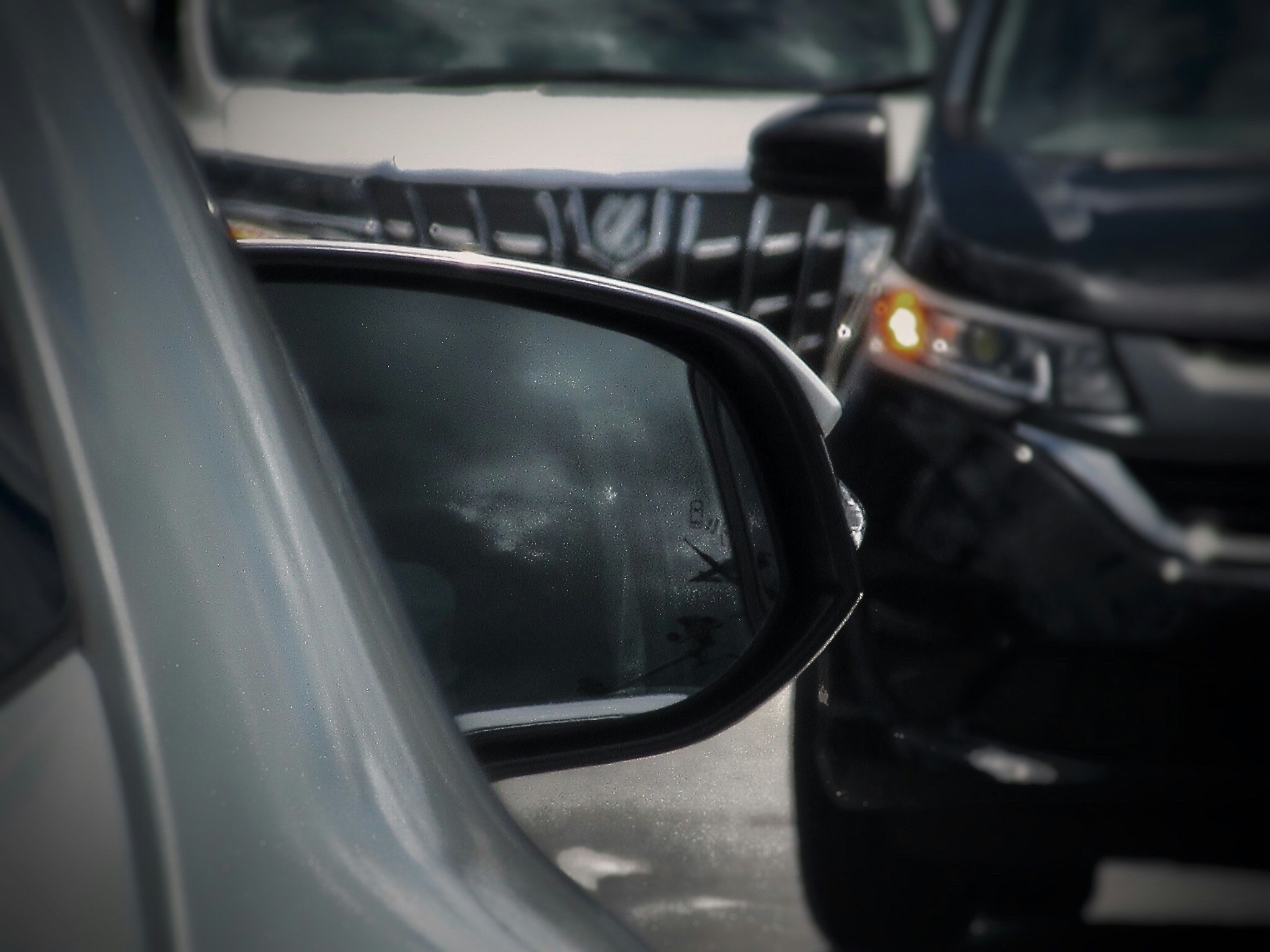 交差点前の車同士がすれ違う瞬間のバックミラーとウインカー点滅