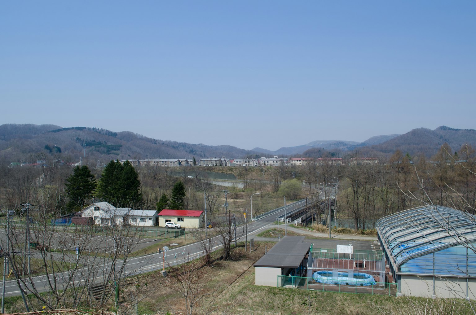 푸른 하늘 아래의 농촌 풍경 집과 산이 보인다