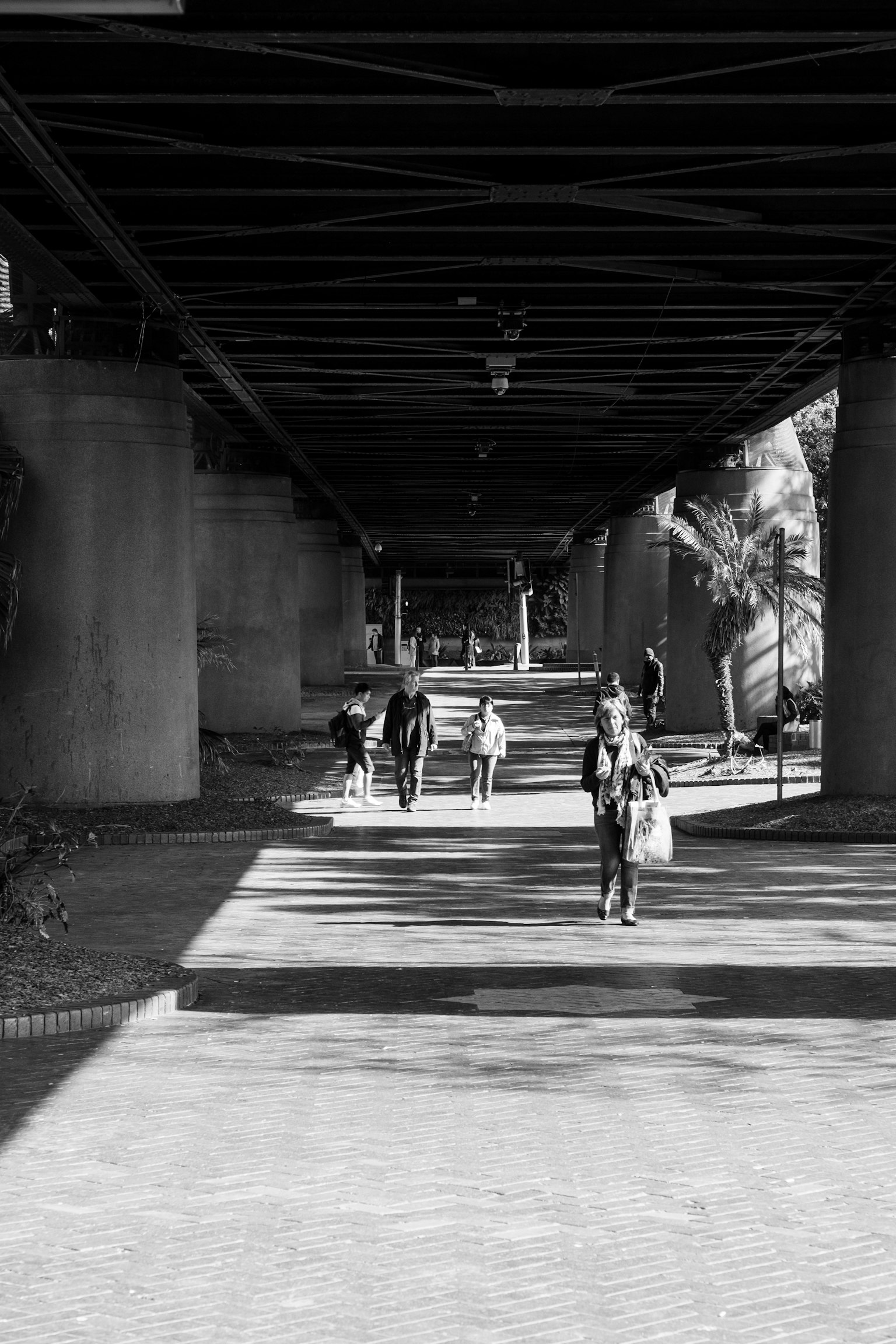 People walking under a black and white tunnel