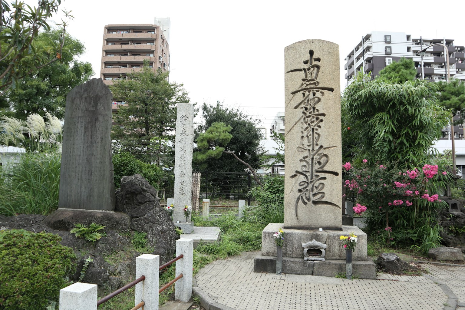 Monument en pierre dans un parc entouré de plantes vertes